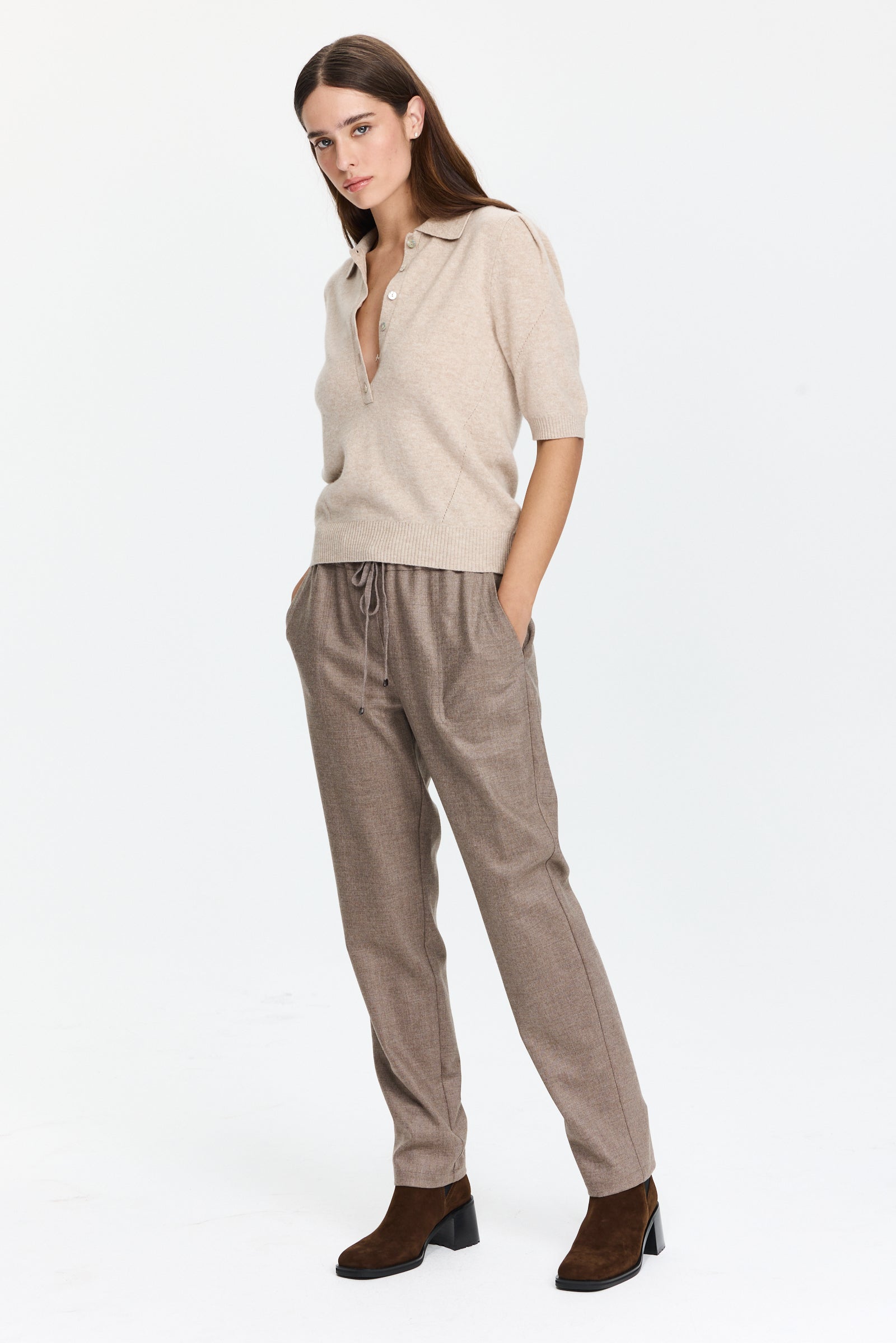 מכנסיים בגזרה ישרה בגוון חום אפרפר עם מותן מתכוונן וחגורת שרוךהרכב בד: 98% צמר, 2% אלסטןהדוגמנית בגובה 1.75 ולובשת מידה 42 של Lorena Antoniazzi