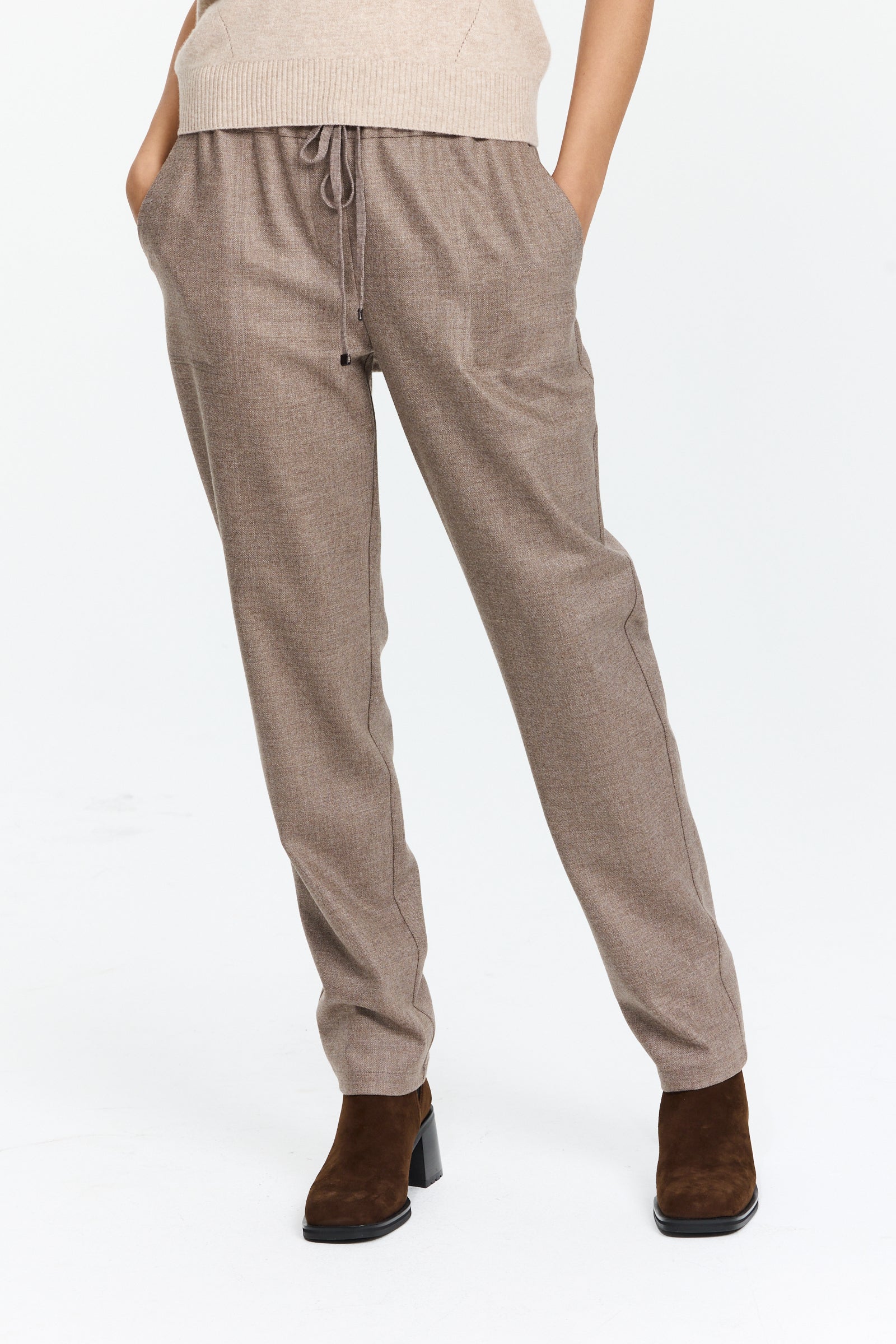 מכנסיים בגזרה ישרה בגוון חום אפרפר עם מותן מתכוונן וחגורת שרוךהרכב בד: 98% צמר, 2% אלסטןהדוגמנית בגובה 1.75 ולובשת מידה 42 של Lorena Antoniazzi