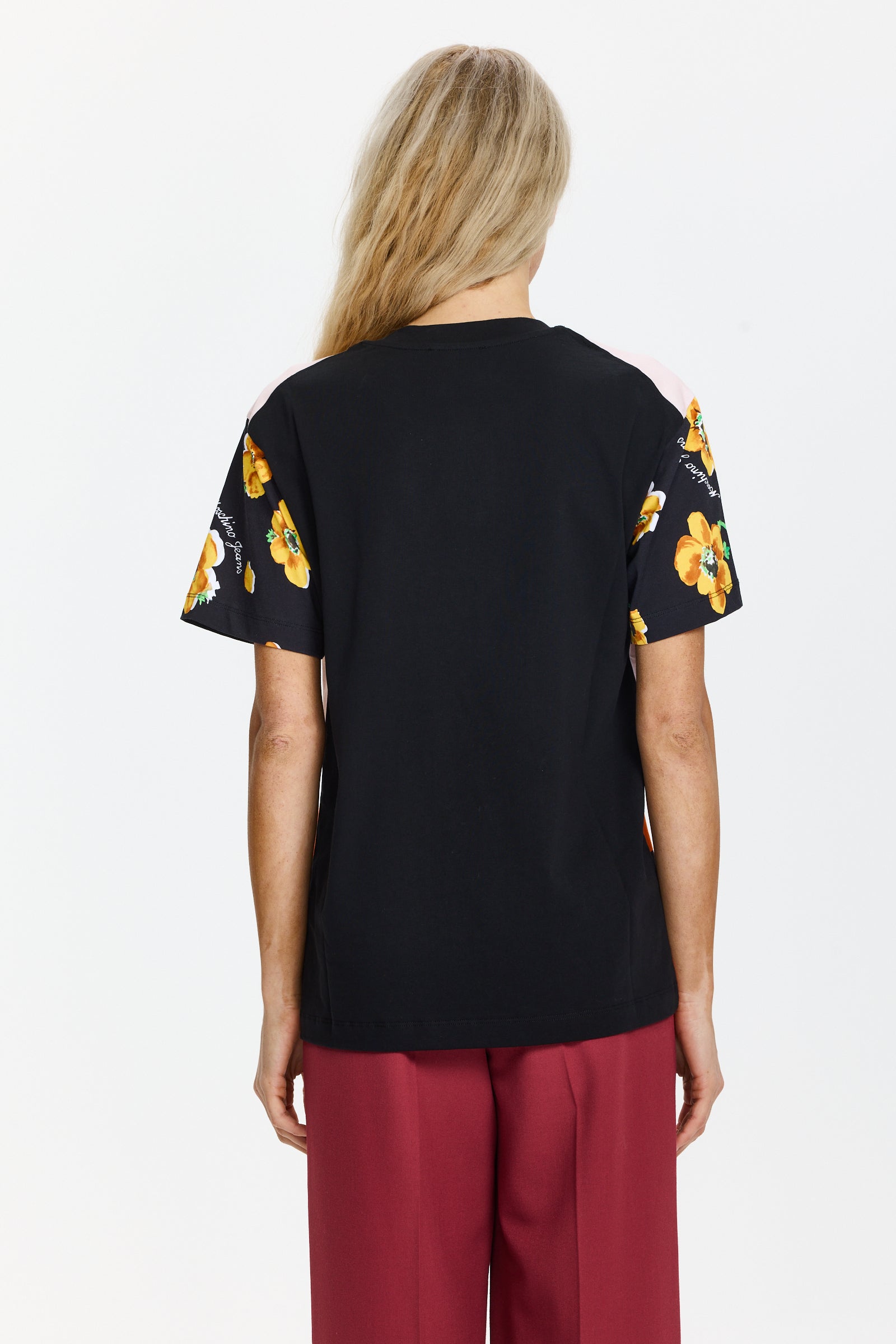 טישרט שחורה עם הדפס גרפי, צווארון עגול ושרוולי קצרהרכב: 100% כותנההדוגמנית בגובה 1.75 ולובשת מידה XS של MOSCHINO