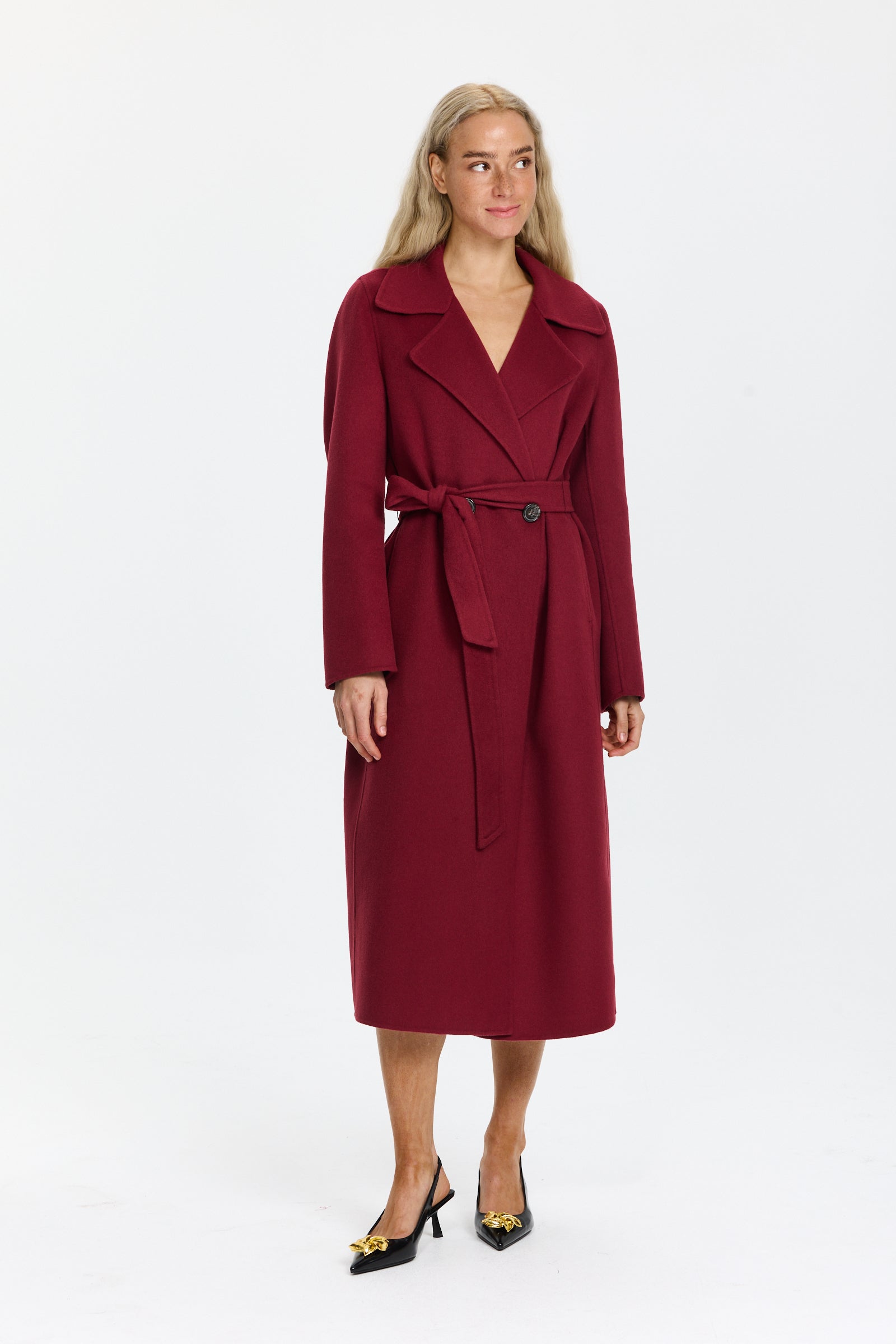 מעיל צמר ארוך קלאסי, עם חגורת קשירה וכפתורים בחזיתהרכב הבד: 85% צמר בתולי, 10% פוליאמיד, 5% קשמירהדוגמנית בגובה 1.75 ולובשת מידה 36 של Luisa Cerano
