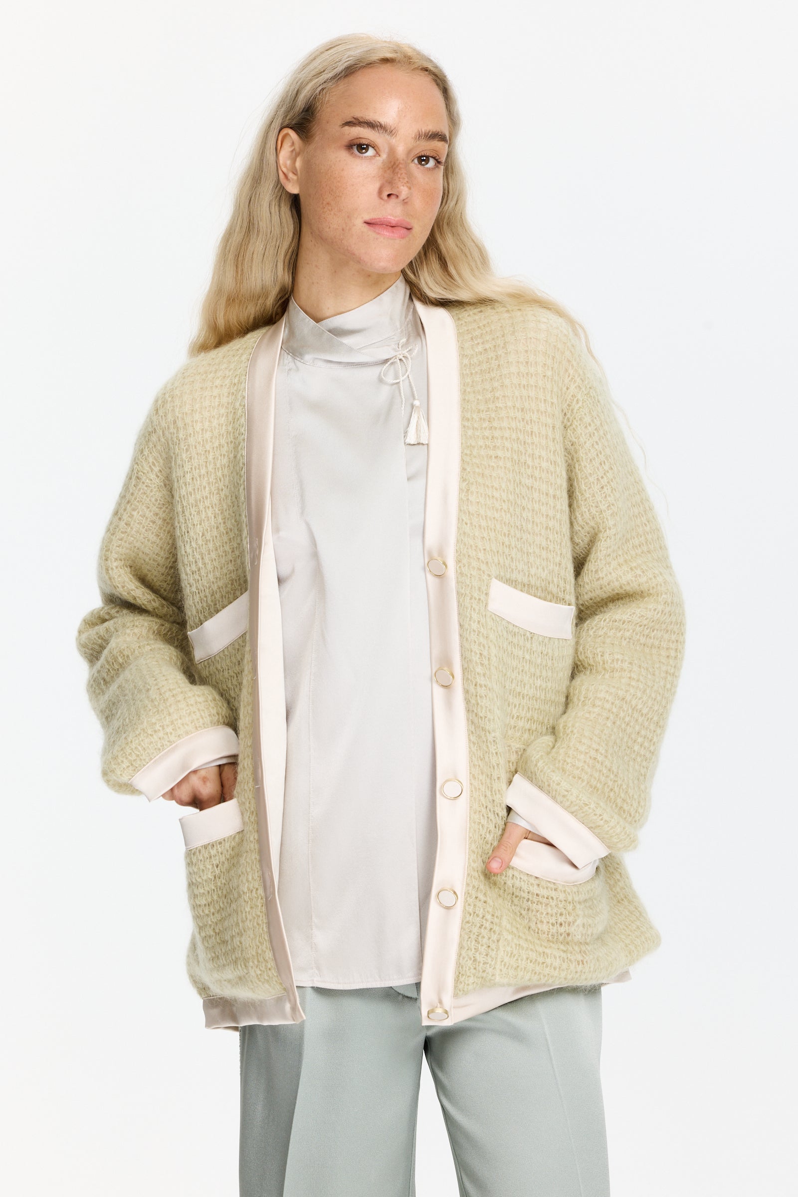 קרדיגן סריג וופל בגזרה רחבה עם כיסים קדמיים, כפתורים, שרוולים ארוכים וגימורים סאטןהרכב הבד: 50% מוהייר, 32% פוליאמיד, 18% צמר בתוליהדוגמנית בגובה 1.75 ולובשת מידה I של Forte Forte