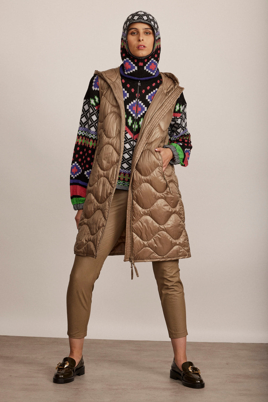 וסט פוך ארוך עם כובע וכיסי צדהרכב: 100% פוליאמיד; מילוי: 100% פוילאסטר; בטנה: 100% פוליאמידהדוגמנית בגובה 1.80 ולובשת מידה 36 אירופאית