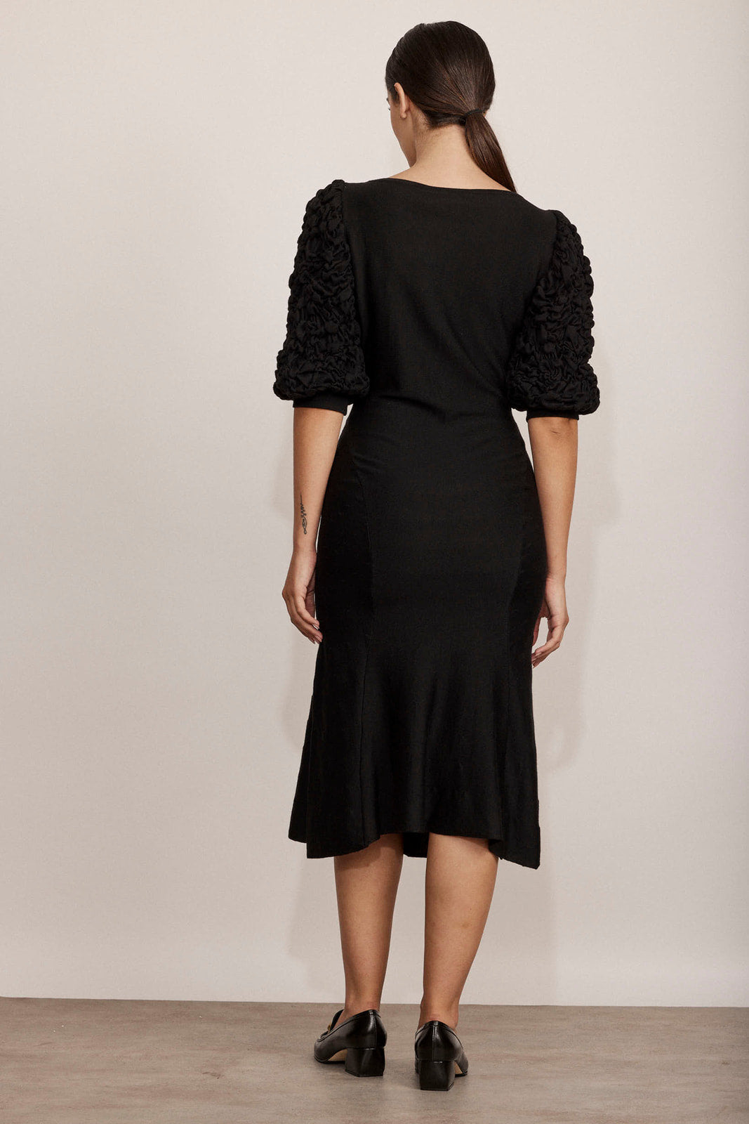 שמלת מידי עם שרוולים נפוחים באורך 3/4 הרכב: 70% צמר וירג'ין, 20% משי, 10% קשמירהדוגמנית בגובה 1.75 ולובשת מידה 42 איטלקית