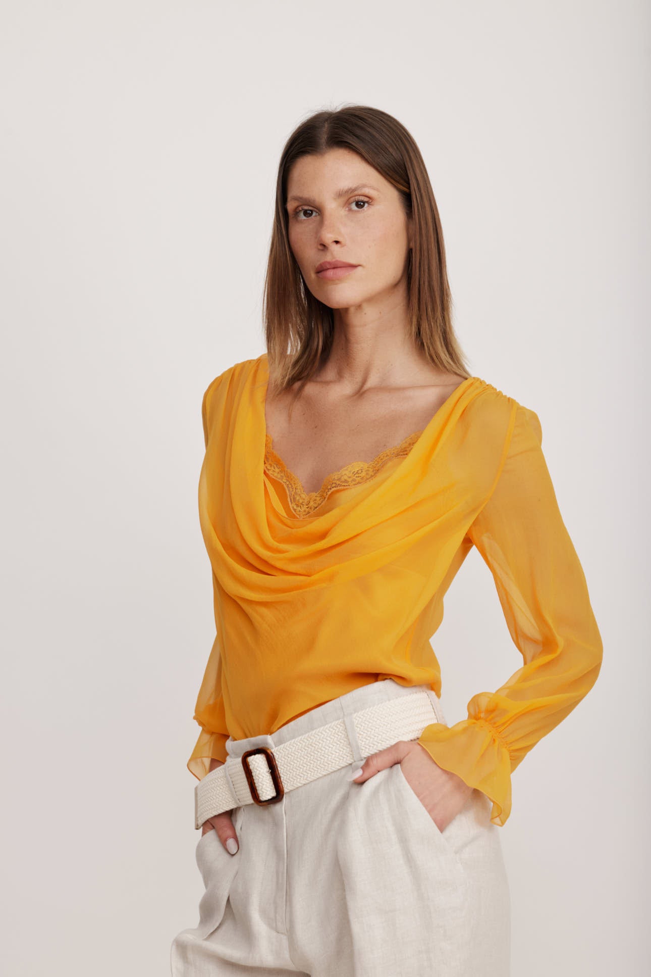 חולצת בלוזון מבד משי עם כיווצים עדינים לאורך קו הצווארון וסיומת תחרה הרכב: 100% משי; בד משני: 100% פוליאמידהדוגמנית בגובה 1.80 ולובשת מידה 40 איטלקית