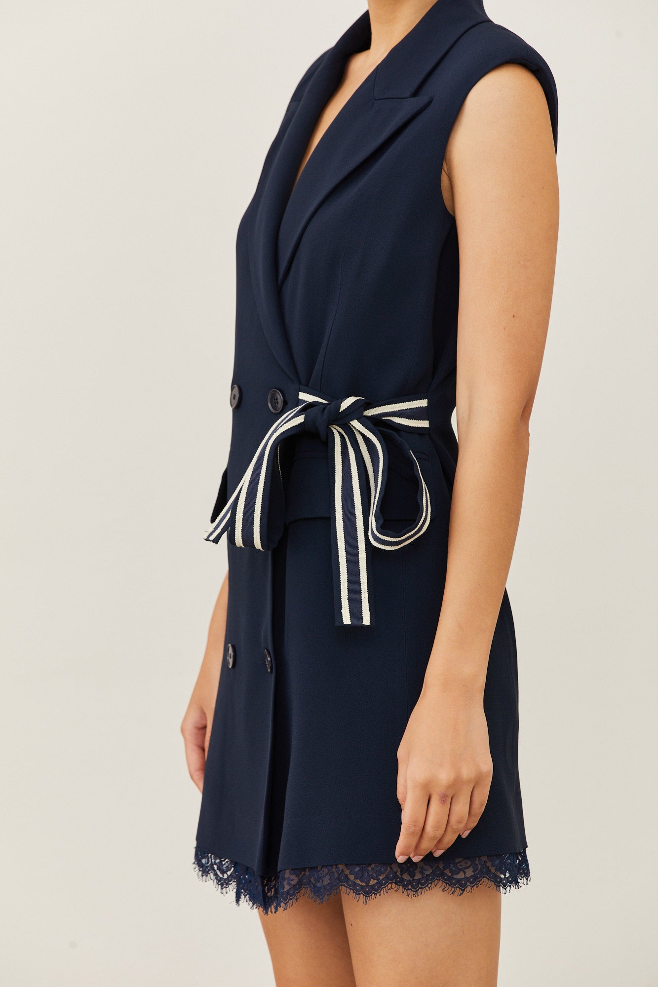 שמלה מחוייטת בסגנון מעטפת בגזרת מיניהרכב: 70% אצטט, 30% ויסקוזה; בטנה: 94% אצטט, 6% ויסקוזה; תחרה: 80% כותנה, 20% פוליאמיד; חגורה צידית: 50% כותנה, 50% ויסקוזההדוגמנית בגובה 1.73 ולובשת מידה 40 איטלקית