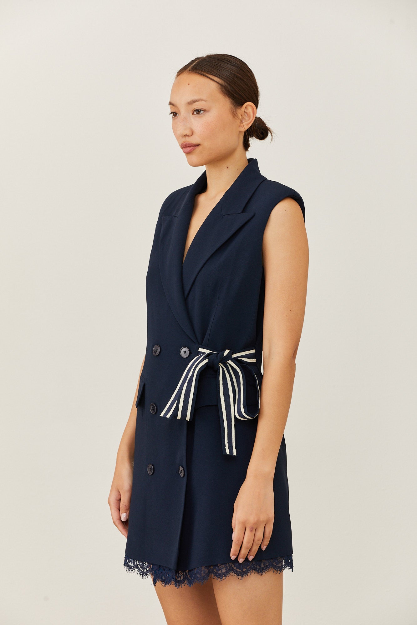 שמלה מחוייטת בסגנון מעטפת בגזרת מיניהרכב: 70% אצטט, 30% ויסקוזה; בטנה: 94% אצטט, 6% ויסקוזה; תחרה: 80% כותנה, 20% פוליאמיד; חגורה צידית: 50% כותנה, 50% ויסקוזההדוגמנית בגובה 1.73 ולובשת מידה 40 איטלקית