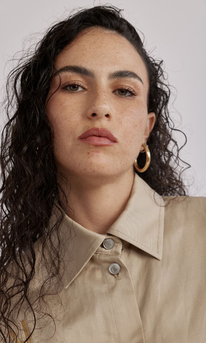 חולצה גזרת קרופ מכופתרת בעיטור אטב מוזהב הרכב: 56% ליוסל, 26% פשתן, 18% כותנההדוגמנית בגובה 1.78 ולובשת מידה 40 של MOSCHINO