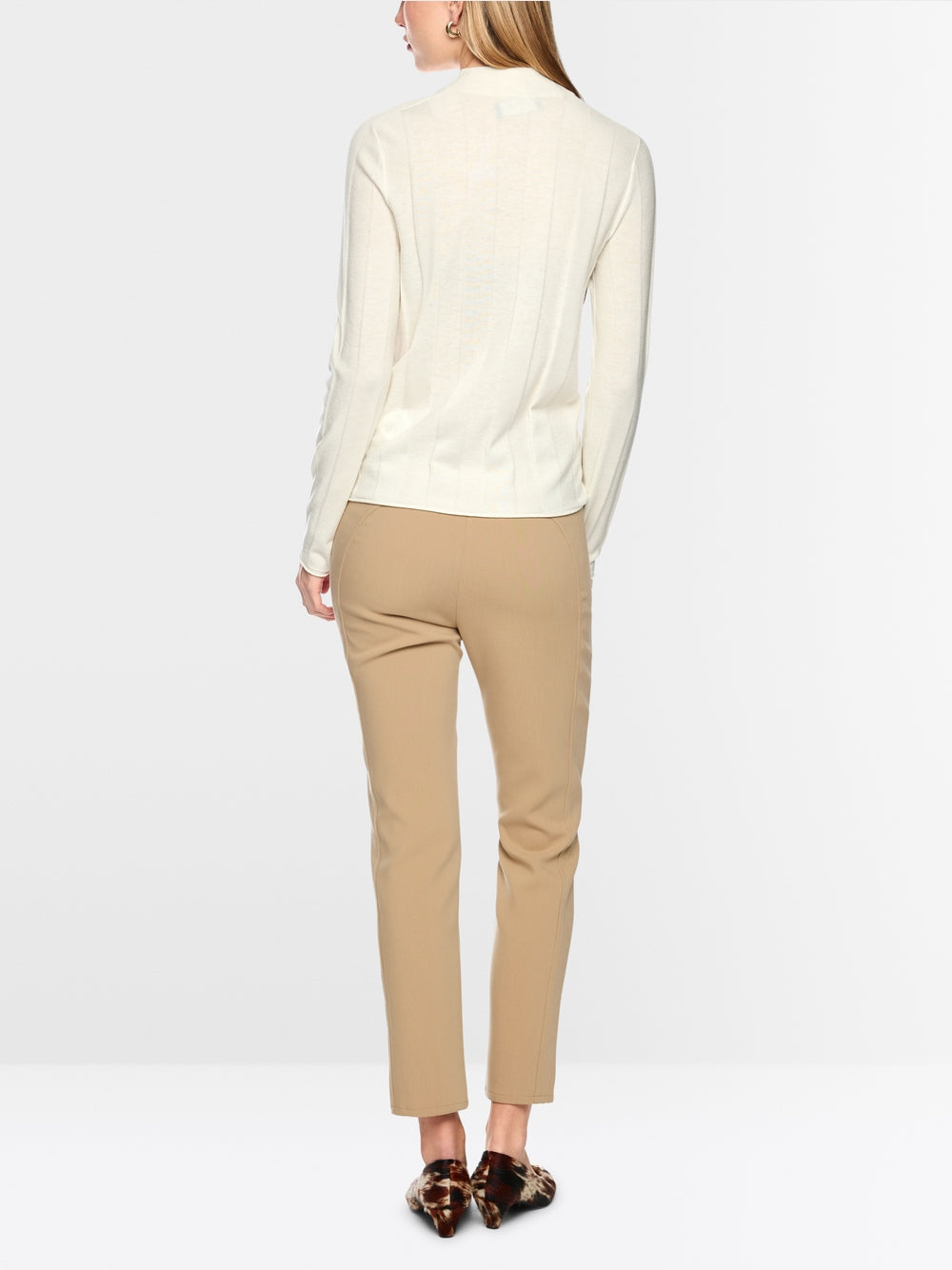 סוודר סריג עדין בגזרה צרה (Slim fit), המשלב אלגנטיות על-זמנית עם נוחות יוצאת דופן. תערובת צמר חדש איכותית עם כמות קטנה של קשמיר מעניקה חום נעים ותחושה רכה. מרקם עדין מוסיף נגיעה עכשווית. צווארון עומד קלאסי ומכפלות מגולגלות משלימים את המראה.עיצוב בגזרה צרה, צווארון עומד, מכפלות מגולגלות, ותווית לוגו קטנה.הרכב: 75% צמר טהור, 20% פוליאסטר, 5% קשמירהדוגמנית בגובה 1.79 ולובשת מידה 3 של מארק קיין