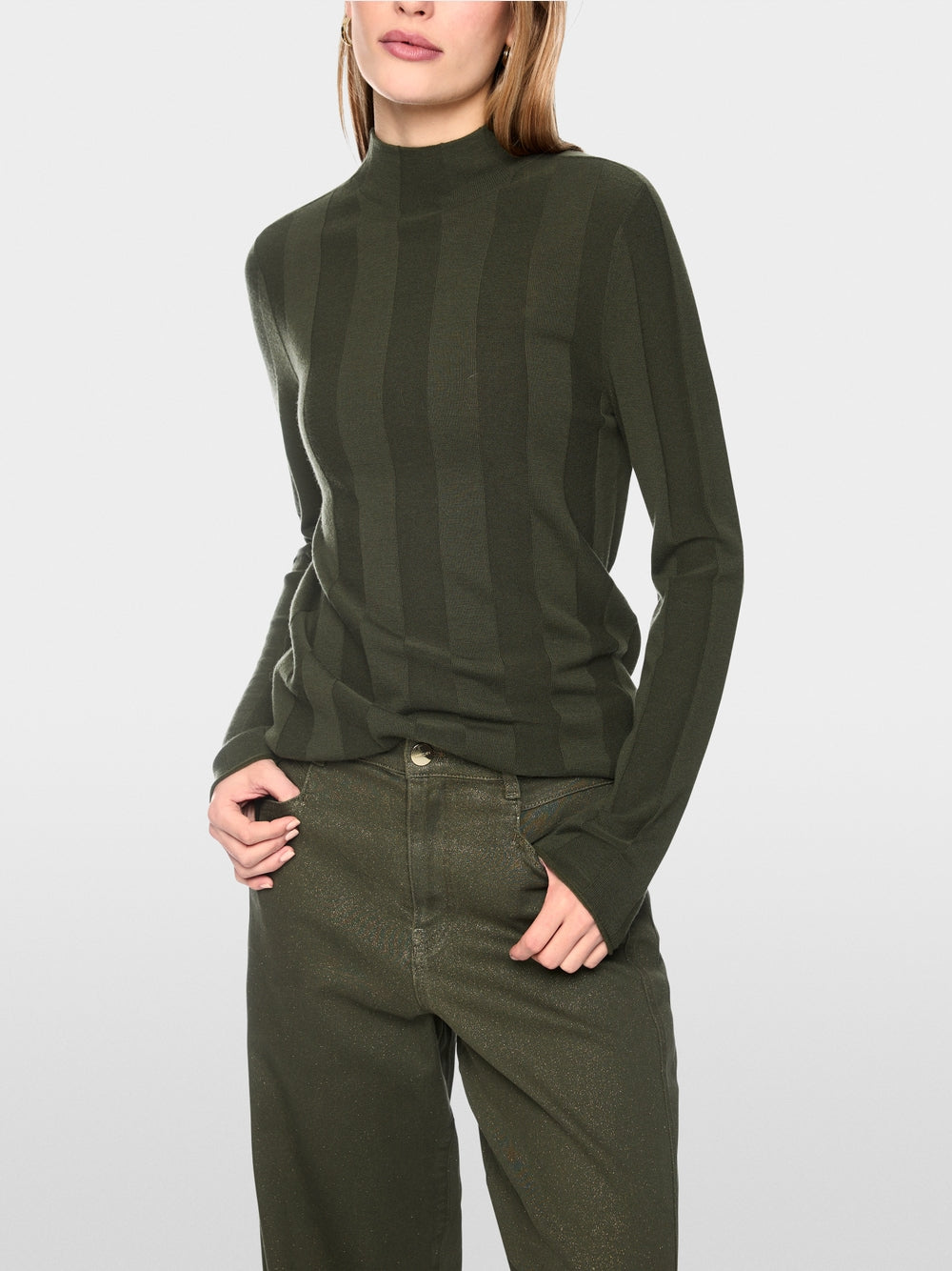 סוודר סריג עדין בגזרה צרה (Slim fit), המשלב אלגנטיות על-זמנית עם נוחות יוצאת דופן. תערובת צמר חדש איכותית עם כמות קטנה של קשמיר מעניקה חום נעים ותחושה רכה. מרקם עדין מוסיף נגיעה עכשווית. צווארון עומד קלאסי ומכפלות מגולגלות משלימים את המראה.עיצוב בגזרה צרה, צווארון עומד, מכפלות מגולגלות, ותווית לוגו קטנה.הרכב: 75% צמר טהור, 20% פוליאסטר, 5% קשמירהדוגמנית בגובה 1.79 ולובשת מידה 3 של מארק קיין