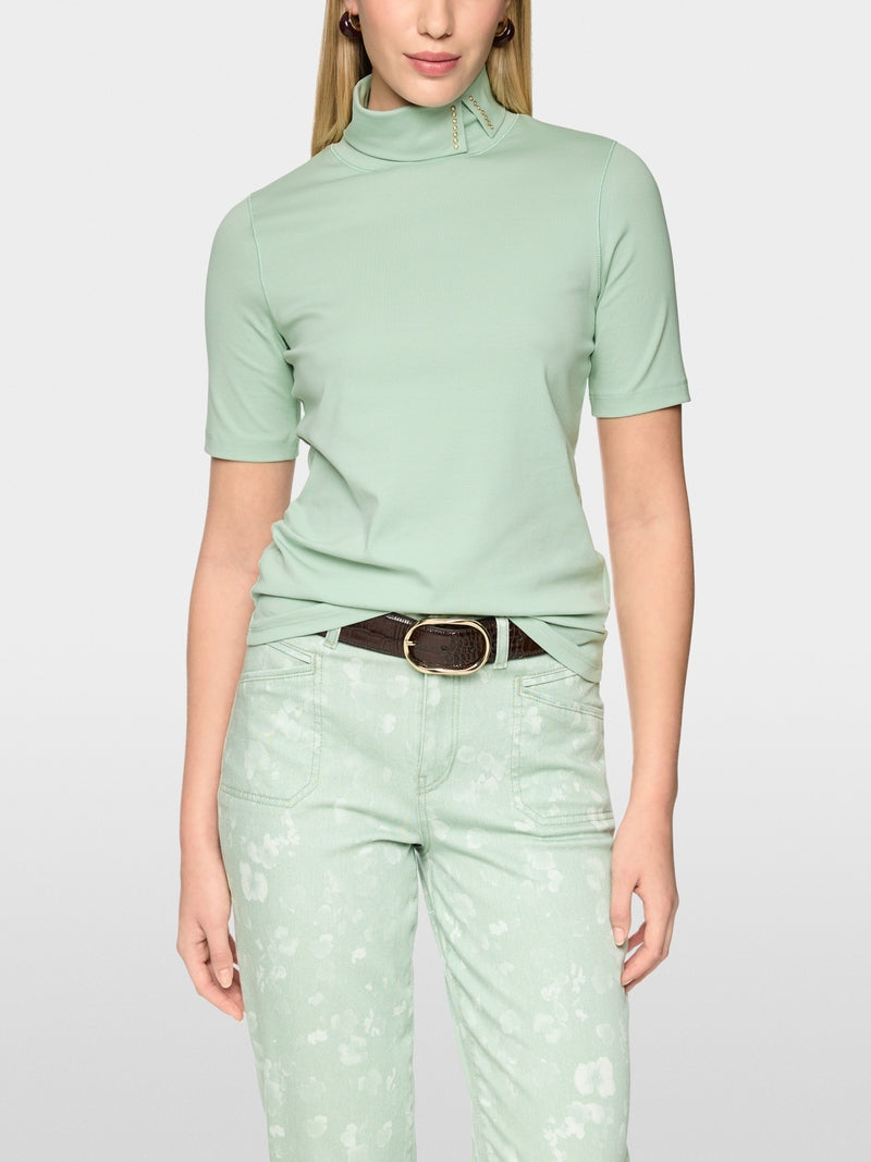 חולצה בגזרה צרה (Slim fit) עם שרוולים קצרים משלבת נוחות עם עיצוב ייחודי. עשויה מכותנה סטרצ'ית רכה, היא מתאימה לקווי הגוף בצורה מושלמת. הדגש הוא על הצווארון העומד עם חריץ: כשהוא מקופל למטה, מתגלה פרט אלגנטי, המעניק למראה טאץ' מתוחכם.עיצוב בגזרה צרה, שרוולים קצרים, צווארון עומד, ופרטים.הרכב: 95% כותנה, 5% אלסטןהדוגמנית בגובה 1.79 ולובשת מידה 3 של מארק קיין