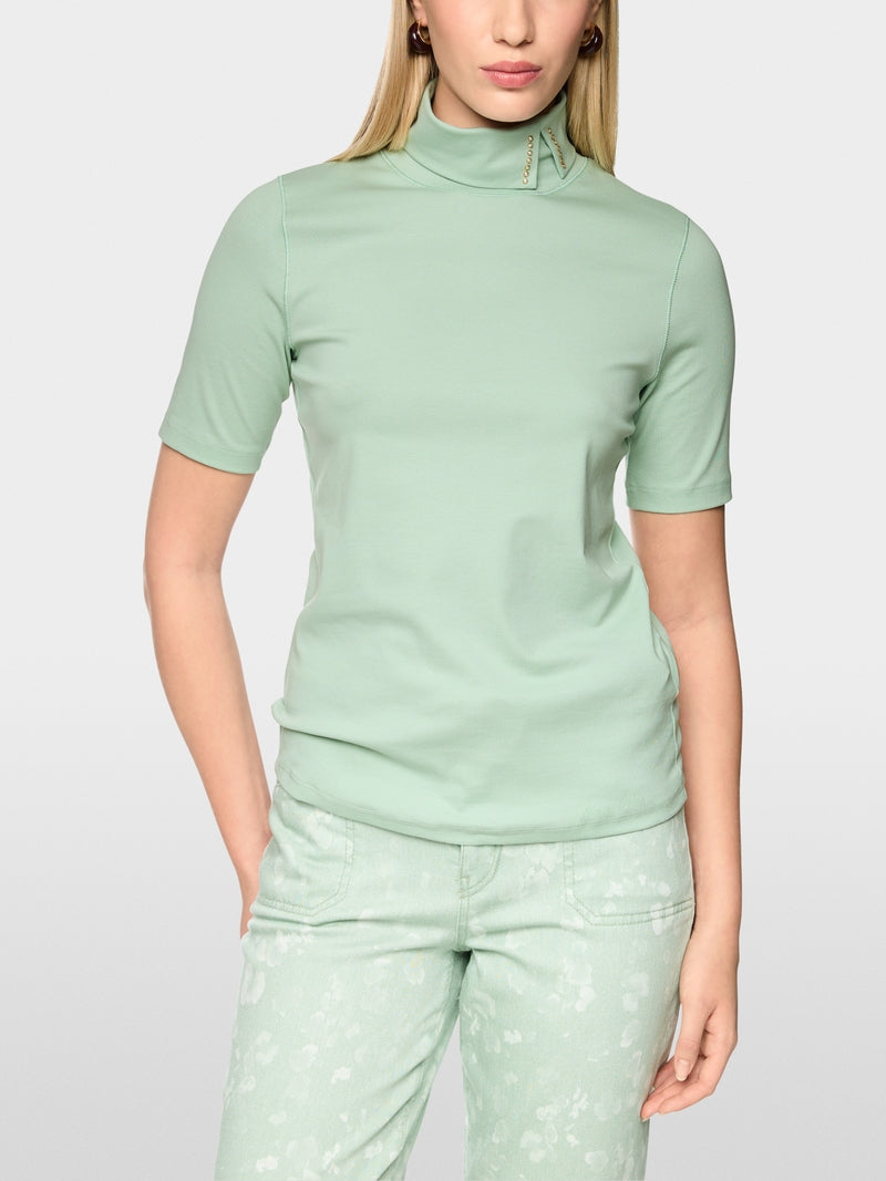 חולצה בגזרה צרה (Slim fit) עם שרוולים קצרים משלבת נוחות עם עיצוב ייחודי. עשויה מכותנה סטרצ'ית רכה, היא מתאימה לקווי הגוף בצורה מושלמת. הדגש הוא על הצווארון העומד עם חריץ: כשהוא מקופל למטה, מתגלה פרט אלגנטי, המעניק למראה טאץ' מתוחכם.עיצוב בגזרה צרה, שרוולים קצרים, צווארון עומד, ופרטים.הרכב: 95% כותנה, 5% אלסטןהדוגמנית בגובה 1.79 ולובשת מידה 3 של מארק קיין