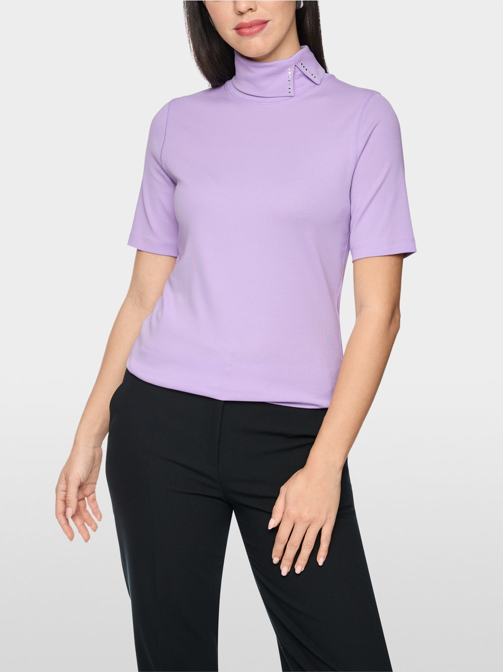 חולצה בגזרה צרה (Slim fit) עם שרוולים קצרים משלבת נוחות עם עיצוב ייחודי. עשויה מכותנה סטרצ'ית רכה, היא מתאימה לקווי הגוף בצורה מושלמת. הדגש הוא על הצווארון העומד עם חריץ: כשהוא מקופל למטה, מתגלה פרט אלגנטי, המעניק למראה טאץ' מתוחכם.עיצוב בגזרה צרה, שרוולים קצרים, צווארון עומד, ופרטים.הרכב: 95% כותנה, 5% אלסטןהדוגמנית בגובה 1.79 ולובשת מידה 3 של מארק קיין