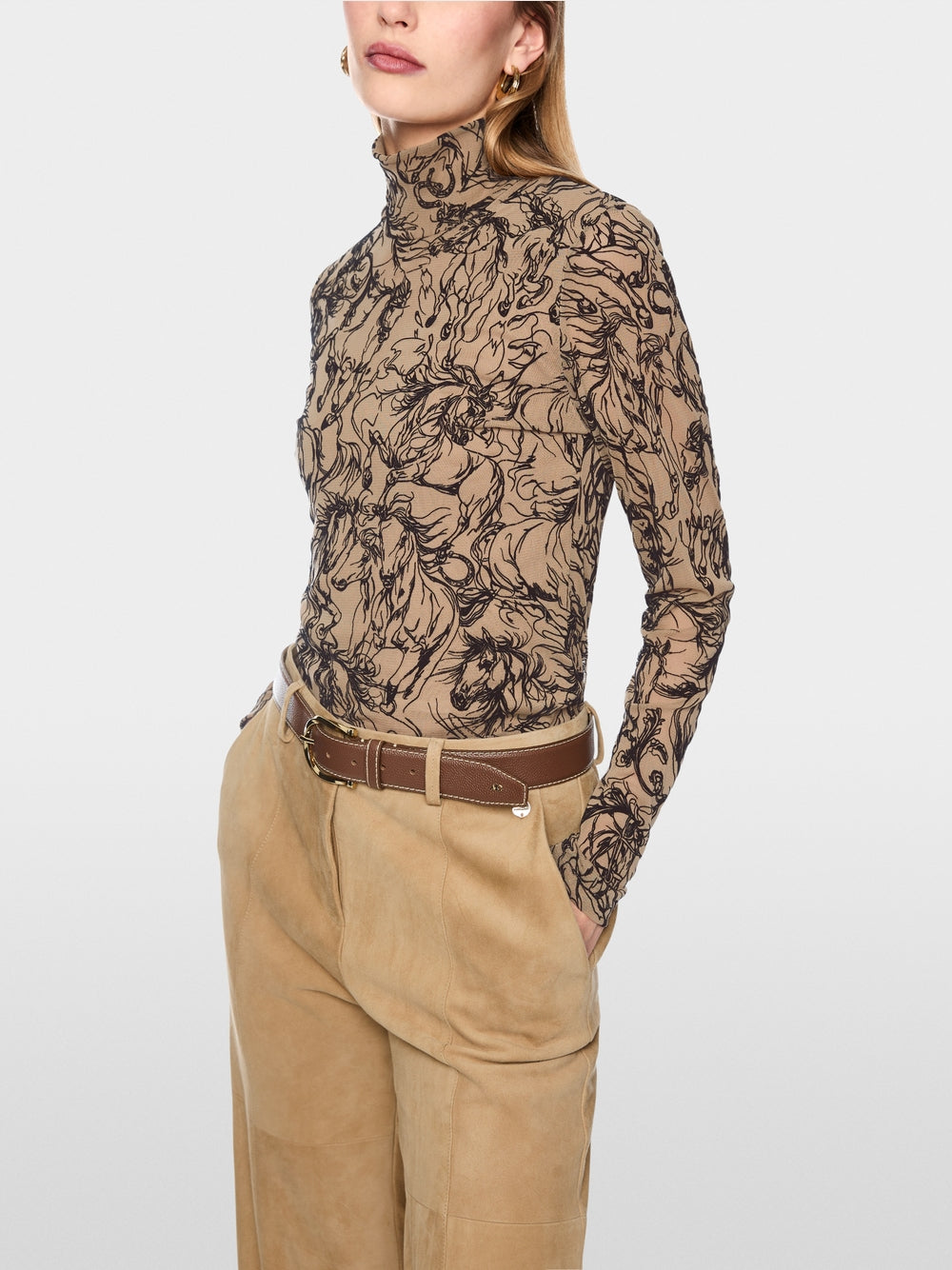חולצה בגזרה צרה (Slim fit) עם שרוולים ארוכים, עשויה בד סטרצ'י אלסטי, המשלבת נוחות עם עיצוב יוצא דופן. צווארון עומד אלגנטי יוצר סילואט עכשווי. הדגש בחולצה הוא על הדפס האיכותי והקטיפתי של סוסים דוהרים.עיצוב בגזרה צרה, צווארון עומד, שרוולים ארוכים, ותווית לוגו קטנה.הרכב: 54% פוליאמיד, 46% ויסקוזההדוגמנית בגובה 1.79 ולובשת מידה 3 של מארק קיין