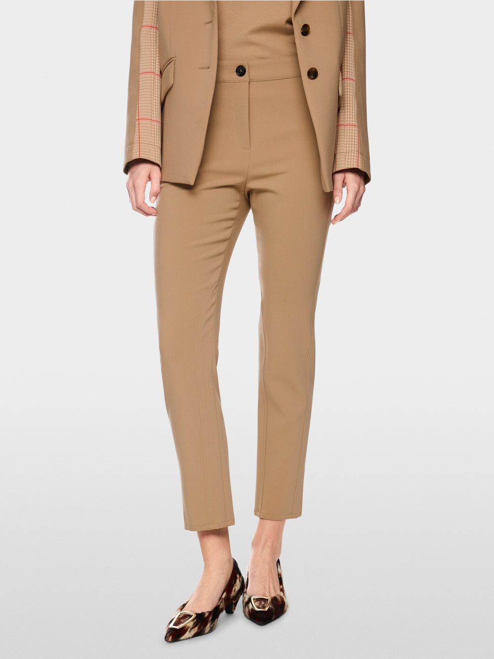 מכנסי SILEA בגזרה צרה (Slim fit), המרשימים בעיצוב הג'ודהפור האלגנטי שלהם. פרט דקורטיבי עדין בהשראת ספורט הרכיבה על הסוסים, על המותניים, מוסיף טאץ' אקסקלוסיבי, בעוד גובה המותן הסטנדרטי עם לולאות לחגורה וסגירת הכפתור והרוכסן הקלאסית מבטיחים התאמה מושלמת. כיסי צד פרקטיים עם רוכסן נסתר וללא תפר משלימים את העיצוב הספורטיבי.עיצוב בגזרה צרה, גובה מותן סטנדרטי, לולאות לחגורה, וכיסי צד עם רוכסן נסתר.הרכב: 45% פוליאסטר, 30% פוליאסטר (ממוחזר), 20% ויסקוזה, 5% אלסטןהדוגמנית בגובה 1.79 ולובשת מידה 3 של מארק קיין
