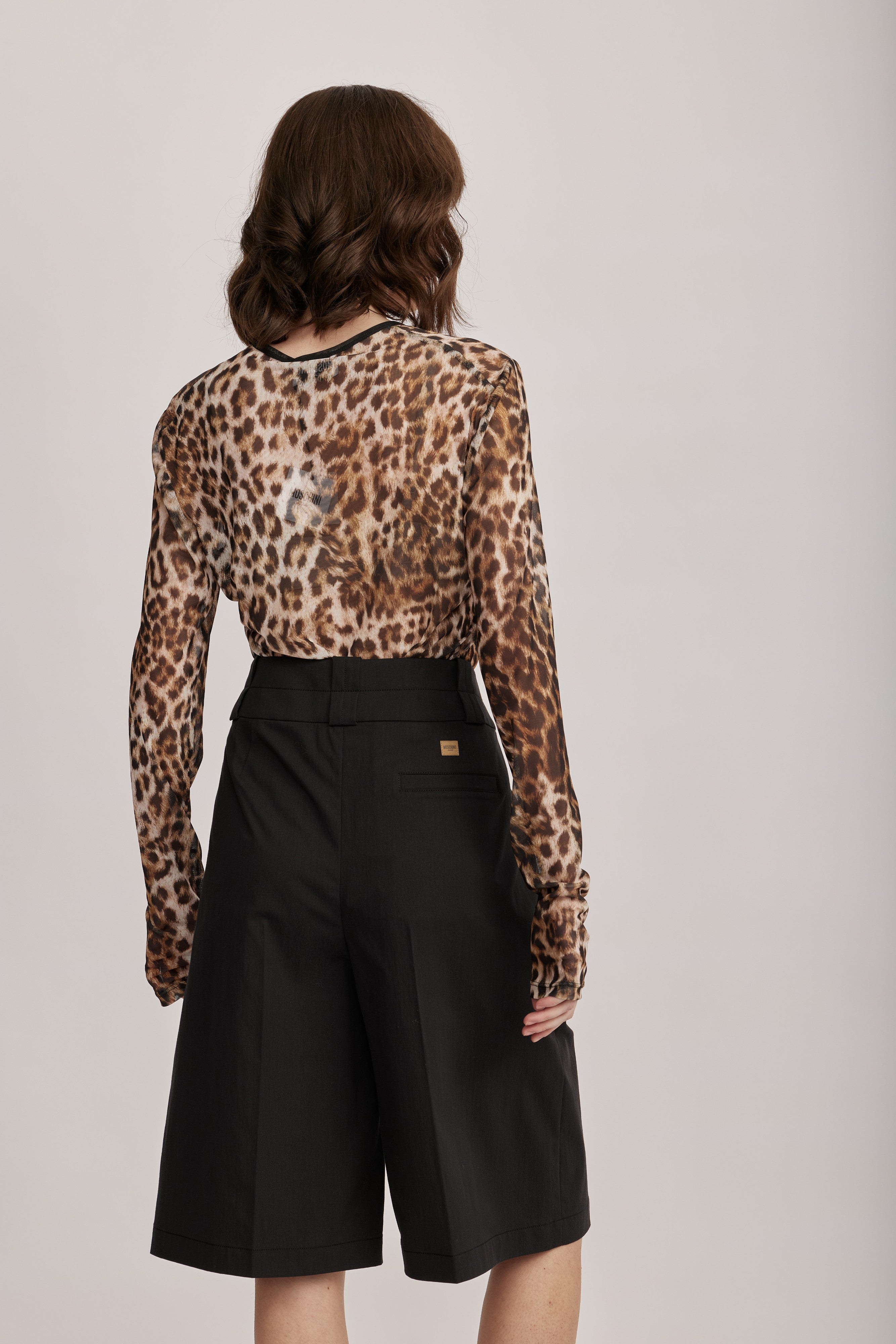 מכנסי ברמודה מליין MOSCHINO JEANS של המותג האיטלקי מוסקינו.גזרה מתרחבת באורך הברך, בצללית A, עם קפלים מודגשים, לולאות לחגורה, וסגירה באמצעות וו ורוכסן נסתר.הרכב: 61% כותנה, 36% פוליאמיד, 3% אלסטןהדוגמנית בגובה 1.75 ולובשת מידה 40 של MOSCHINO