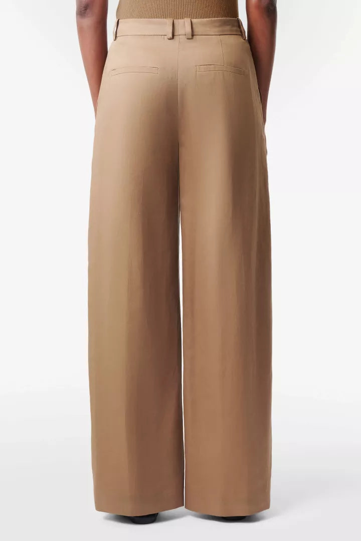 מכנסיים מחוייטים מבית המותג DRYKORN, עשויים בד קליל מתערובת פשתן, למראה אלגנטי ונוח. גזרה רחבה, עם מותן גבוהה, ורגל בצללית barrel עדינה ואופנתית, כיסי צד, לולאות לחגורה, וסגירה באמצעות רוכסן נסתר.הרכב: 38% פשתן, 36% ליוסל, 26% כותנההדוגמנית בגובה 1.78 ולובשת מידה 27 של דרייקורן