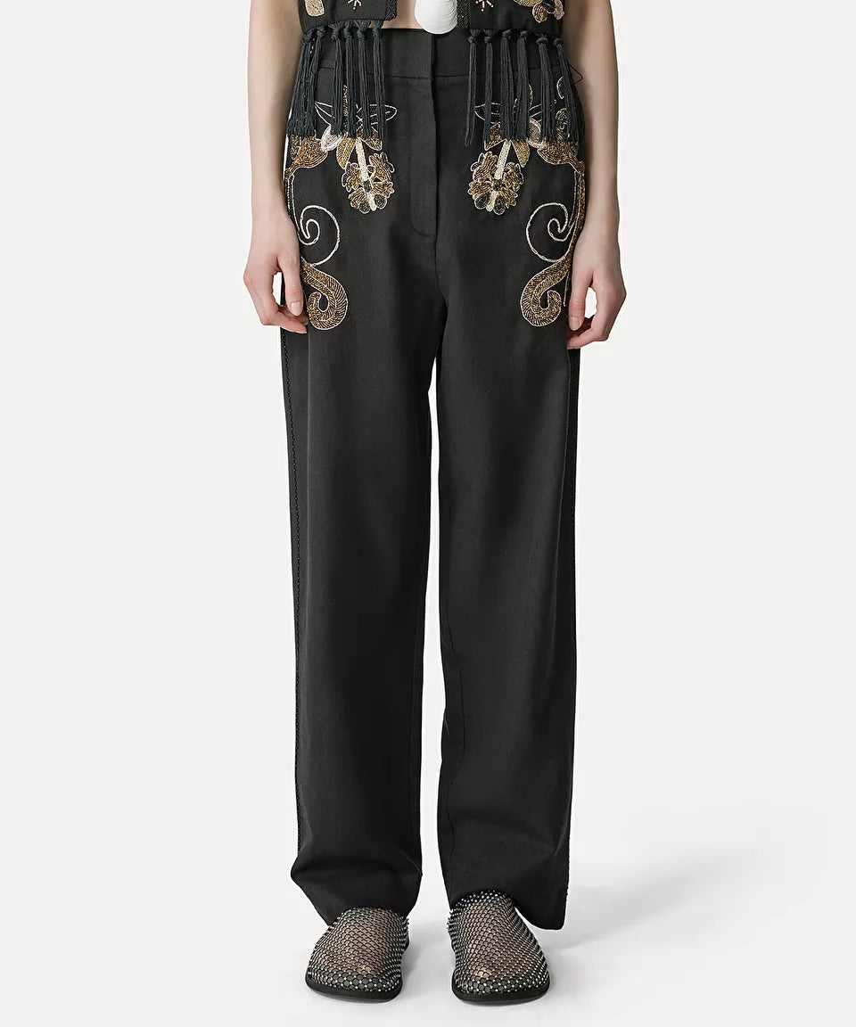 מכנסיים מחוייטים עם עיטור חרוזים הרכב: 60% כותנה, 40% צמרהדוגמנית בגובה 1.77 ולובשת מידה 40 איטלקית (מידה I של פורטה פורטה)