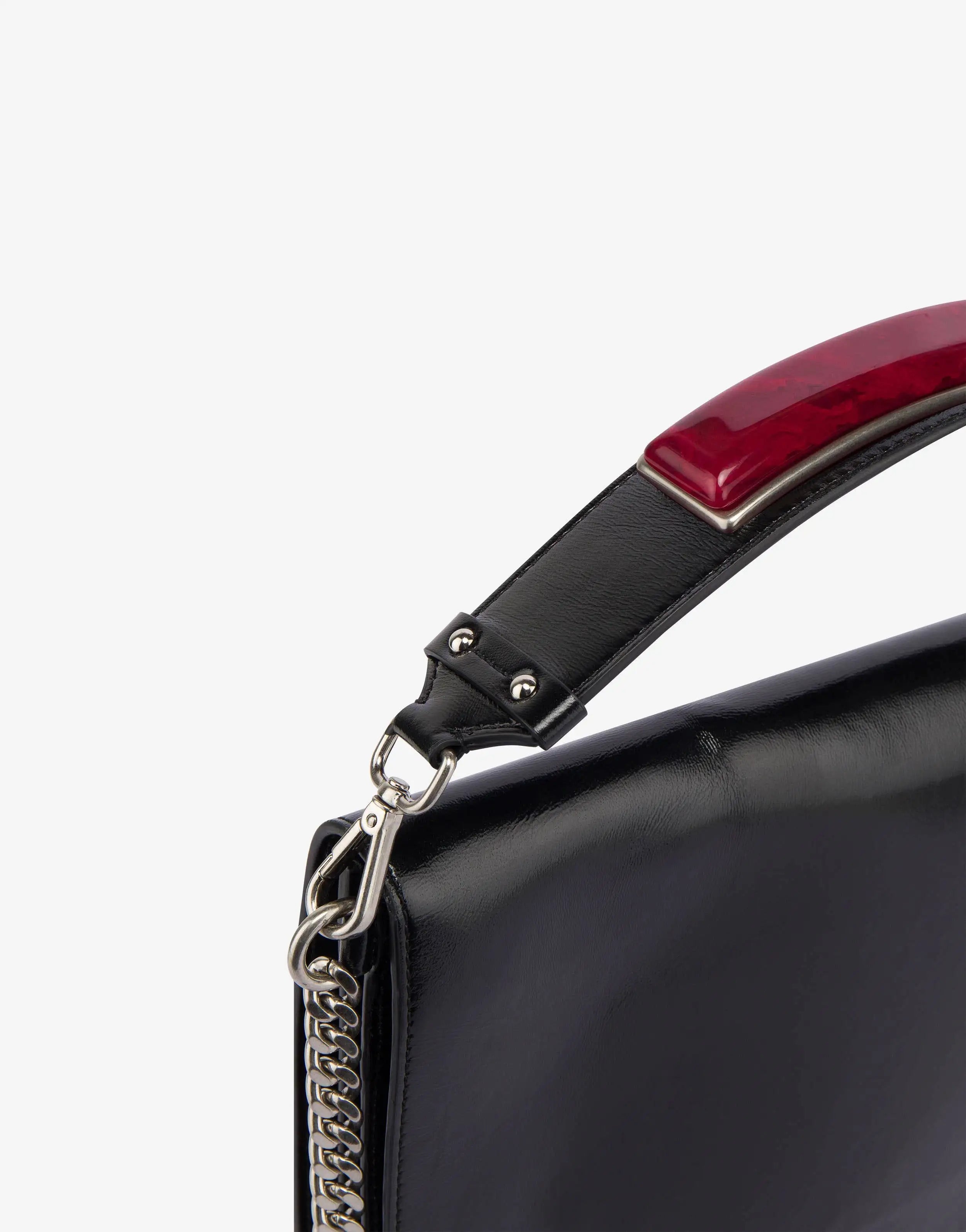 תיק יד מלבני בעיטור אבן חן אדומה על הרצועההרכב: 100% עור נאפהמידות:רוחב - 33 ס"מגובה - 24 ס"מעומק - 2 ס"מרצועת יד - 8 ס"מרצועת מתכת - 50 ס"מ 