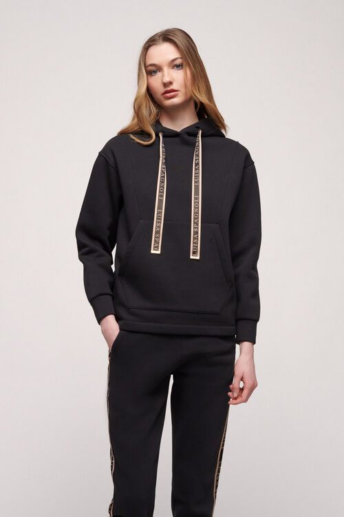 סווטשירט עם קפוצ'ון ושרוכים מונוגרוםהרכב: 65% כותנה, 35% פוליאסטרהדוגמנית בגובה 1.79 ולובשת מידה S