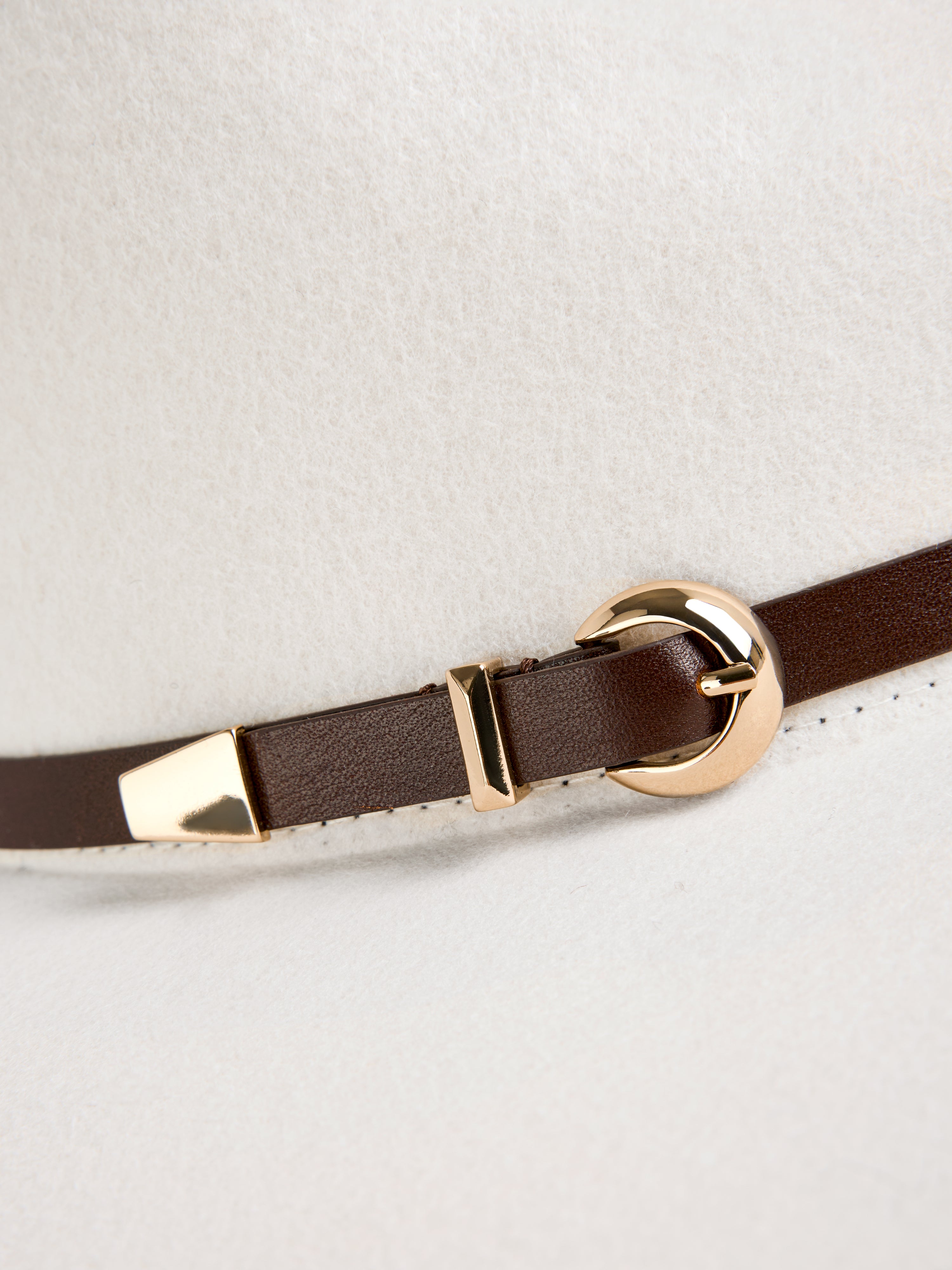 כובע פדורה עשוי צמר רך, מעוטר ברצועת עור ואבזם מתכתי מוזהבהרכב: 100% צמר 