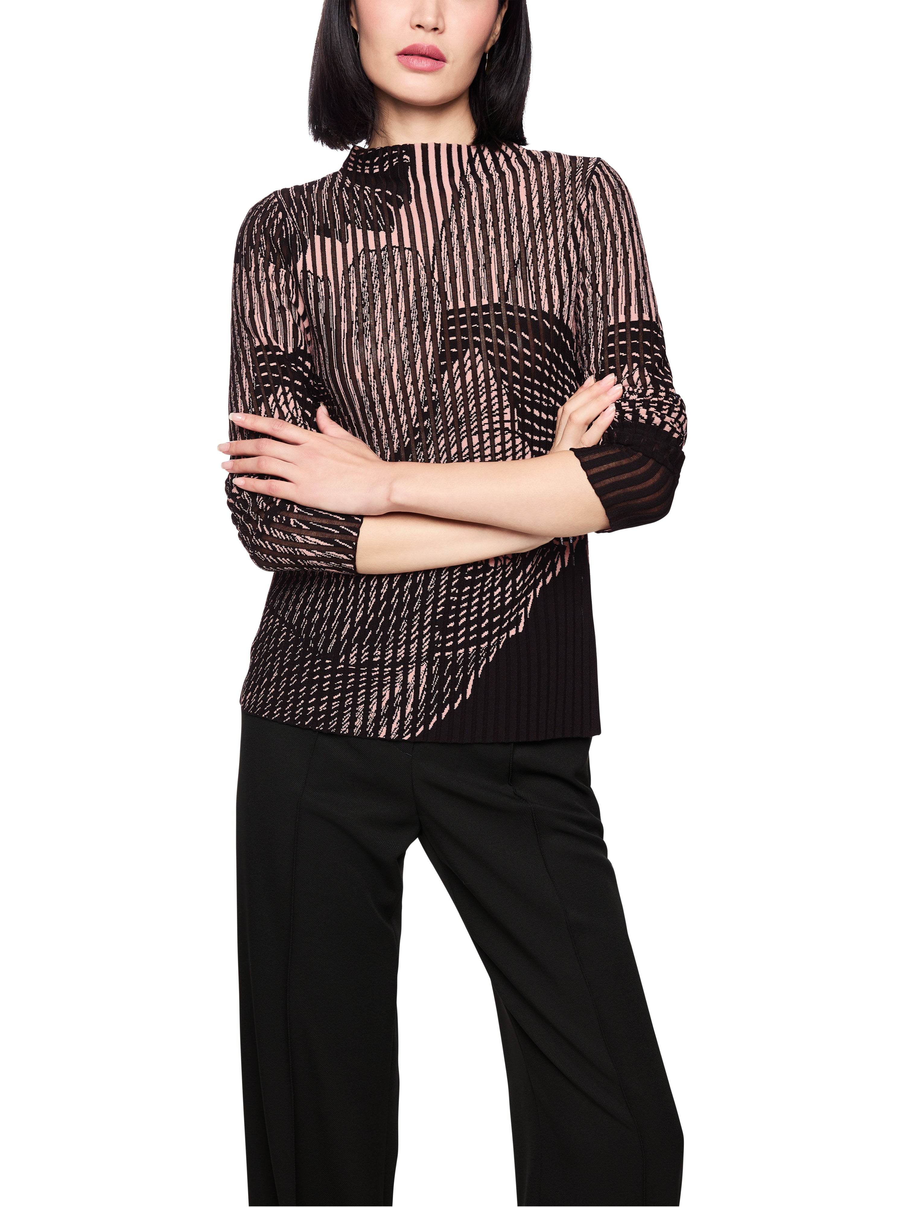 סריג בגזרה צמודה עשוי מג'קארד דו-גווני מעט שקוף, הכולל הדפס פרחוניהרכב: 73% ויסקוזה (ממוחזר), 14% כותנה, 10% פוליאסטר, 3% פוליאמידהדוגמנית בגובה 1.79 ולובשת מידה 3 של מארק קיין 