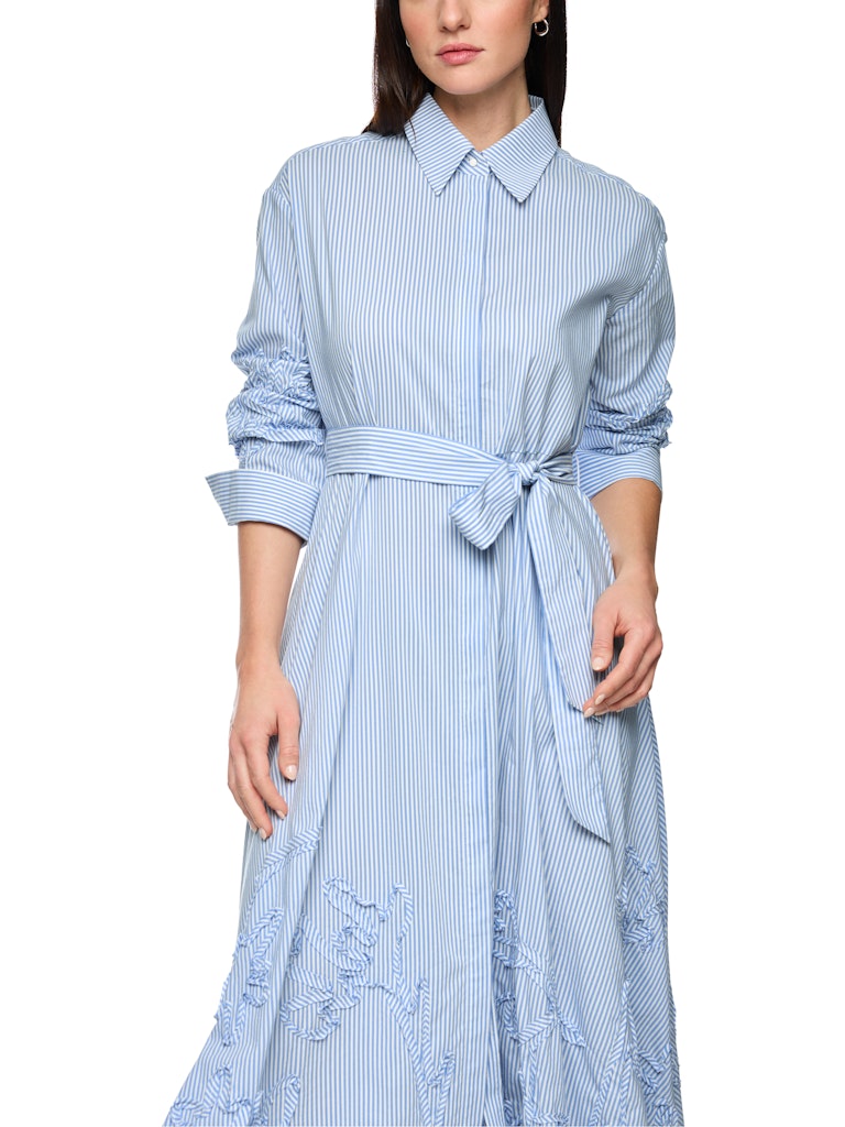 שמלת מידי בעיצוב קז'ואל-אלגנטי, עשויה בד רך וקליל בדוגמת פסים בגווני תכלת ולבן. גזרה נינוחה, עם חגורת מותן נלווית הניתנת לקשירה, להדגשת הצללית הנשית. חצאית מתרחבת, עם נפילה עשירה וזורמת. תוספת דיטייל של עיטור רקמה בדוגמה פרחונית בשרוולים ובחצאית מעניקה לשמלה טוויסט מודרני וייחודי.סגירת כפתורים נסתרת לכל האורך, צווארון קלאסי, ושרוולים ארוכים בסיומת חפתים מכופתרים רחבים המאפשרים התאמת אורך אישית.הרכב: 65% כותנה, 32% פוליאסטר, 3% אלסטןהדוגמנית בגובה 1.79 ולובשת מידה 3 של מארק קיין