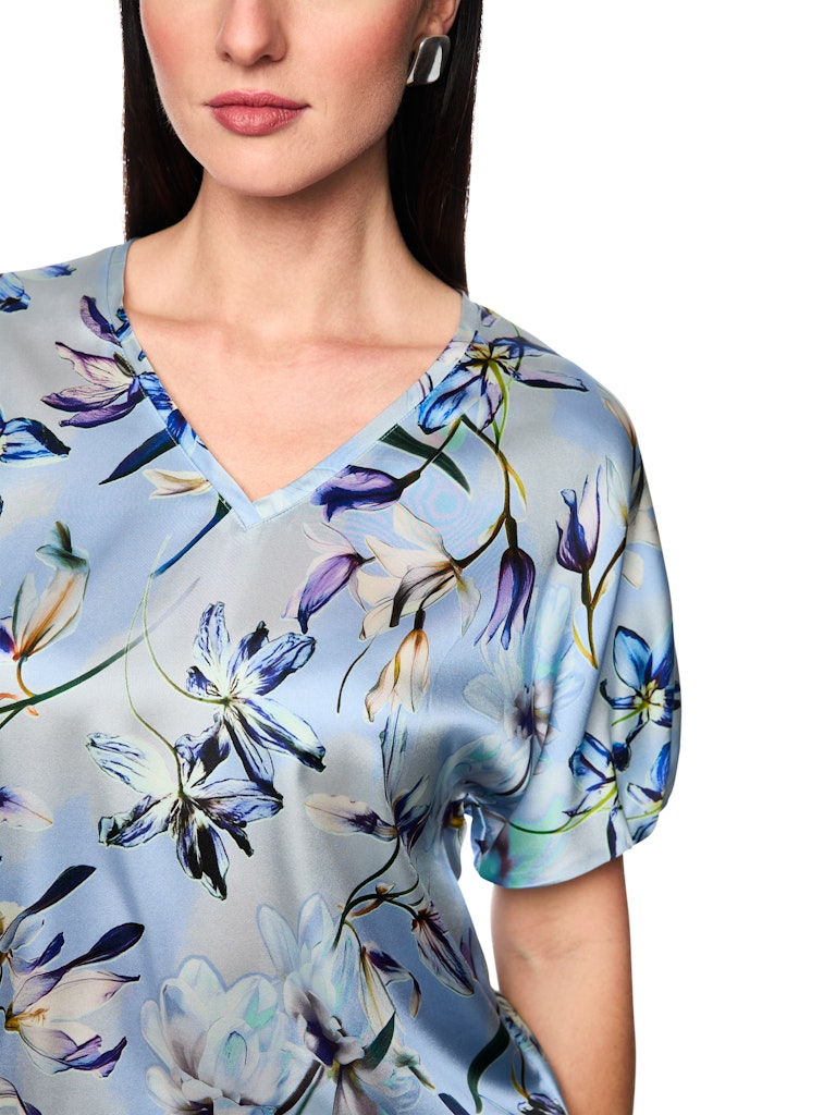 חולצה אלגנטית עשויה בד רך וקליל מתערובת משי. גזרה נשית ונינוחה, עם שרוולי עטלף קצרים, צווארון וי, והדפס פרחוני עדין.הרכב: 92% משי, 8% אלסטןהדוגמנית בגובה 1.79 ולובשת מידה 3 של מארק קיין 