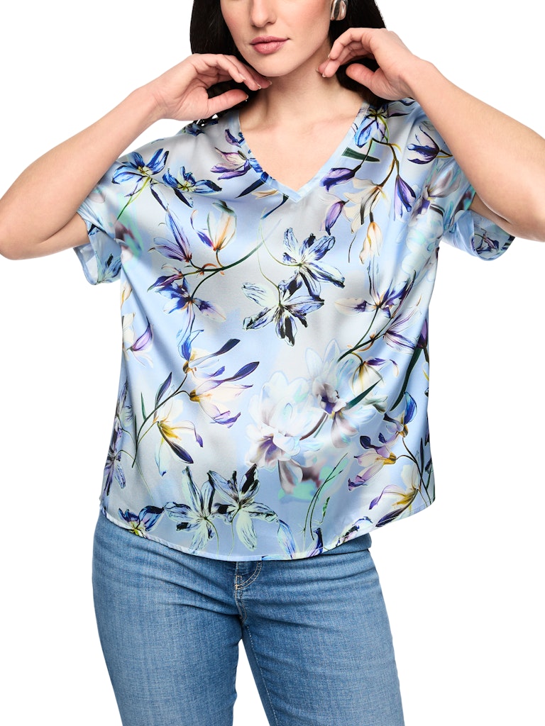חולצה אלגנטית עשויה בד רך וקליל מתערובת משי. גזרה נשית ונינוחה, עם שרוולי עטלף קצרים, צווארון וי, והדפס פרחוני עדין.הרכב: 92% משי, 8% אלסטןהדוגמנית בגובה 1.79 ולובשת מידה 3 של מארק קיין 