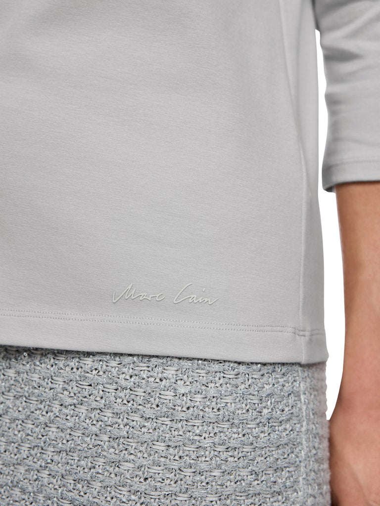 חולצת טישירט בגזרה צמודה לגוף, מבד כותנה ג'רזי רך ונעים. עם צווארון סירה ושרוולים באורך ¾.הרכב: 92% כותנה, 8% אלסטןהדוגמנית בגובה 1.79 ולובשת מידה 3 של מארק קיין