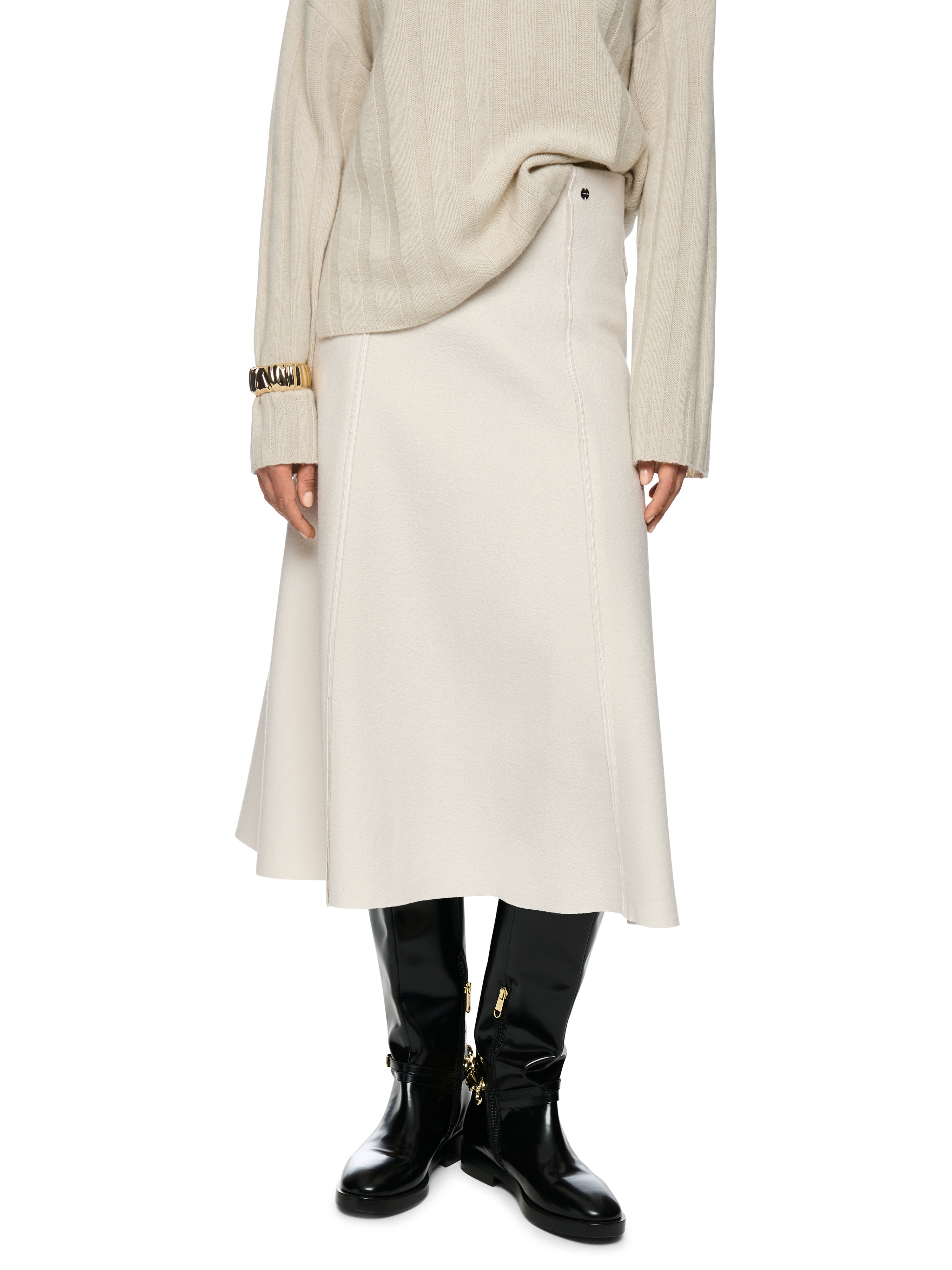 חצאית מתרחבת באורך מידי עם מותן אלסטית ובטנה פנימיתכוללת פסי תפירה עדינים ועיטור לוגו הרכב בד: 100% צמר חדשהדוגמנית בגובה 1.79 ולובשת מידה 3 של מארק קיין