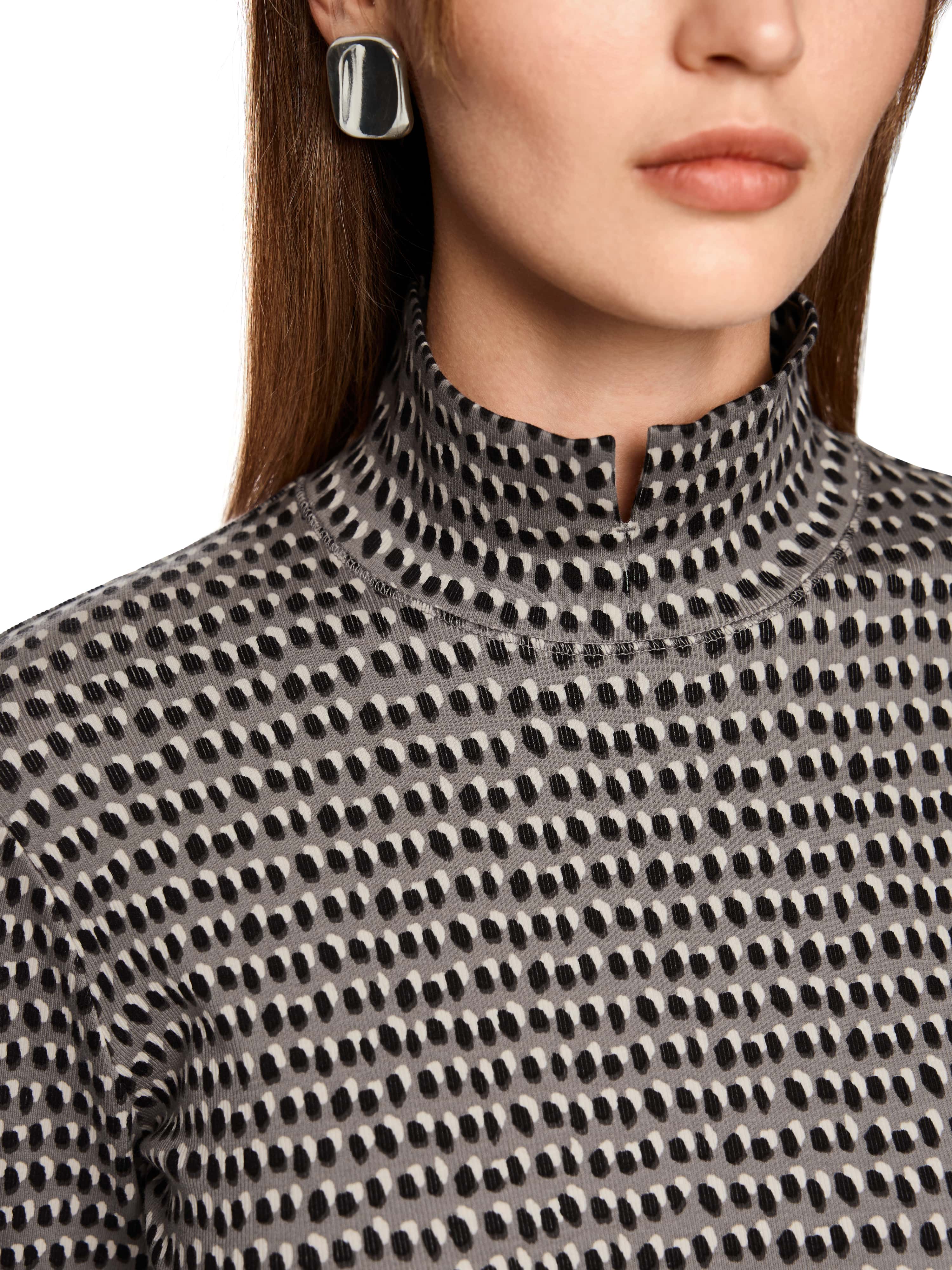 חולצת שרוול ארוך עם הדפס נקודות, בגזרה צמודה ועם צווארון עומד ופתח קטן בחזיתהשרוולים מסתיימים בגימור רחב עם פתח צדדי וכפתור דקורטיביהרכב בד: 94% כותנה, 6% אלסטןהדוגמנית בגובה 1.79 ולובשת מידה 3 של מארק קיין