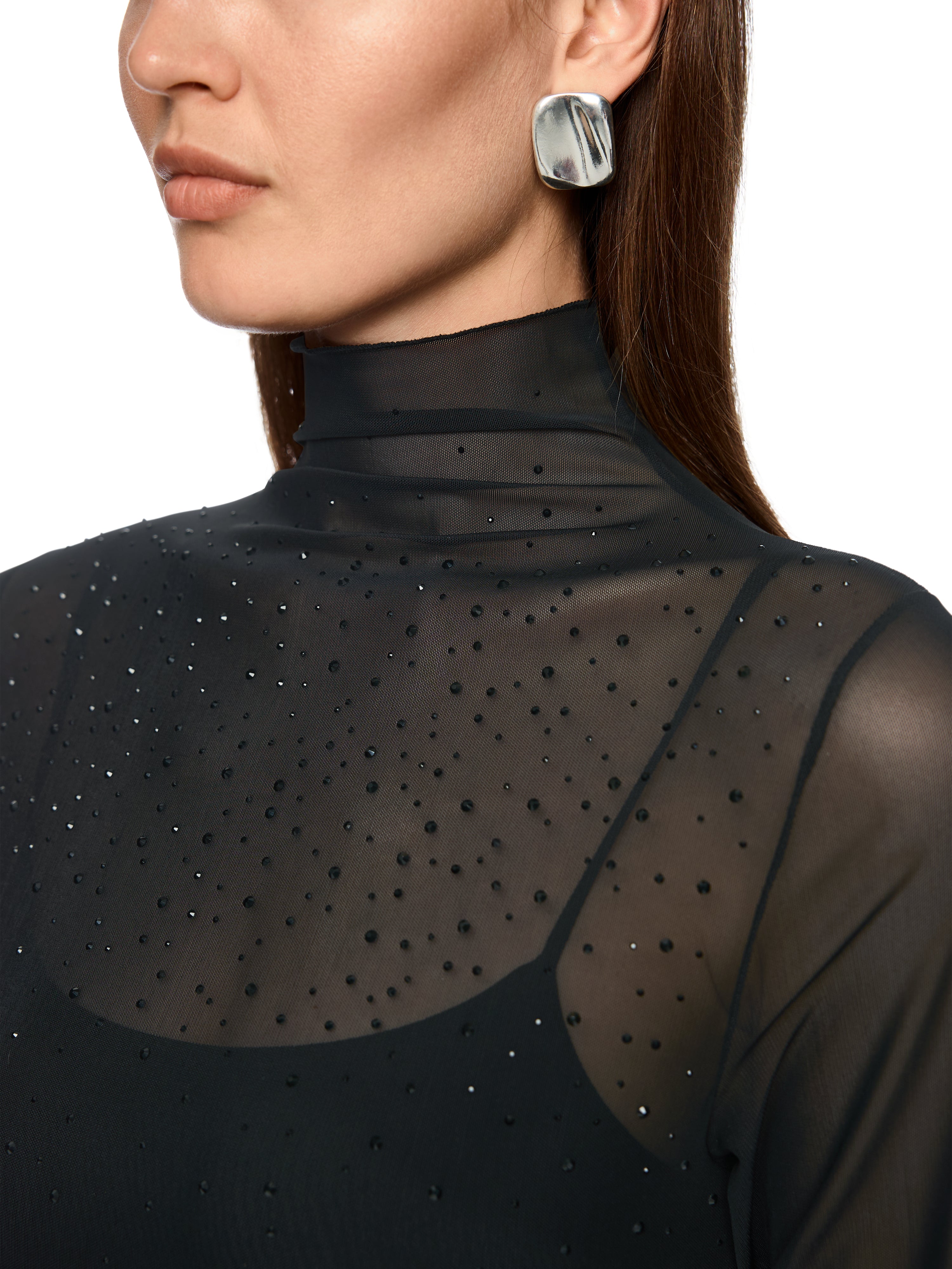 חולצת רשת צמודה עם שרוולים ארוכים וצווארון גבוהמעוטרת באבנים מנצנצות בחזיתהרכב בד: 90% פוליאסטר, 10% אלסטןהדוגמנית בגובה 1.79 ולובשת מידה 3 של מארק קיין