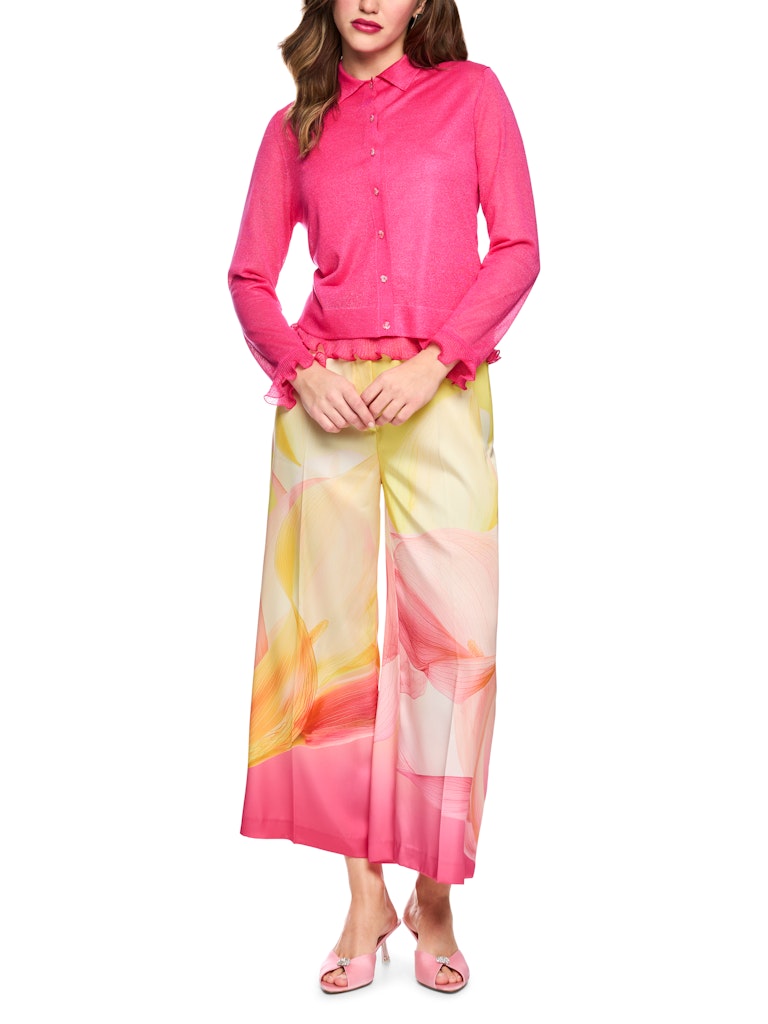 קרדיגן דק וקליל, עשוי סריג שקפקף מתערובת ויסקוזה ומשי רכה, בשילוב חוט לורקס למראה ברק עדין. גזרה ישרה, עם צווארון קלאסי, ושרוולים ארוכים בגימור מסולסל. סגירה באמצעות שורת כפתורים דקורטיביים עדינים בצורת פרח.הרכב: 73% ויסקוזה, 19% פוליאסטר, 8% משיהדוגמנית בגובה 1.79 ולובשת מידה 3 של מארק קיין 