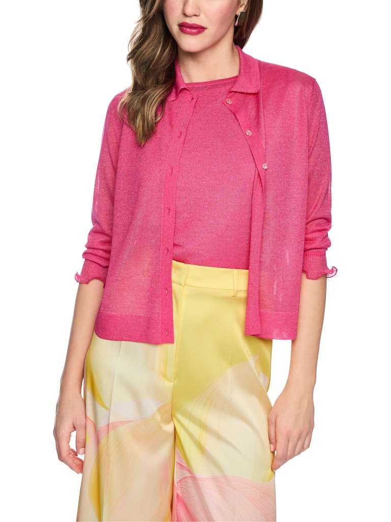 קרדיגן דק וקליל, עשוי סריג שקפקף מתערובת ויסקוזה ומשי רכה, בשילוב חוט לורקס למראה ברק עדין. גזרה ישרה, עם צווארון קלאסי, ושרוולים ארוכים בגימור מסולסל. סגירה באמצעות שורת כפתורים דקורטיביים עדינים בצורת פרח.הרכב: 73% ויסקוזה, 19% פוליאסטר, 8% משיהדוגמנית בגובה 1.79 ולובשת מידה 3 של מארק קיין 