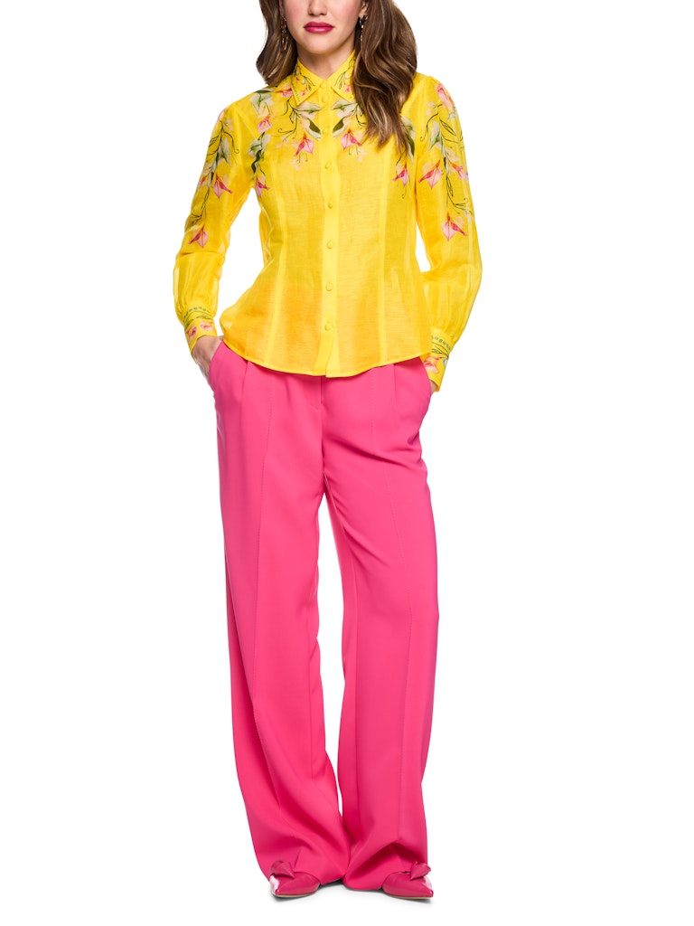 חולצה מכופתרת קלילה ואלגנטית, עשויה תערובת פשתן ומשי איכותית ונעימה. גזרה נשית ונינוחה, עם צווארון קלאסי, שרוולים ארוכים בסיומת חפתים רחבים מכופתרים, וסגירה באמצעות שורת כפתורים קדמית. הדפס צבעוני של דוגמת פרחי קאלה המעטר את החלק העליון של החולצה, הצווארון, והחפתים, מדגיש את העיצוב הייחודי.הרכב: 55% פשתן, 45% משיהדוגמנית בגובה 1.79 ולובשת מידה 3 של מארק קיין