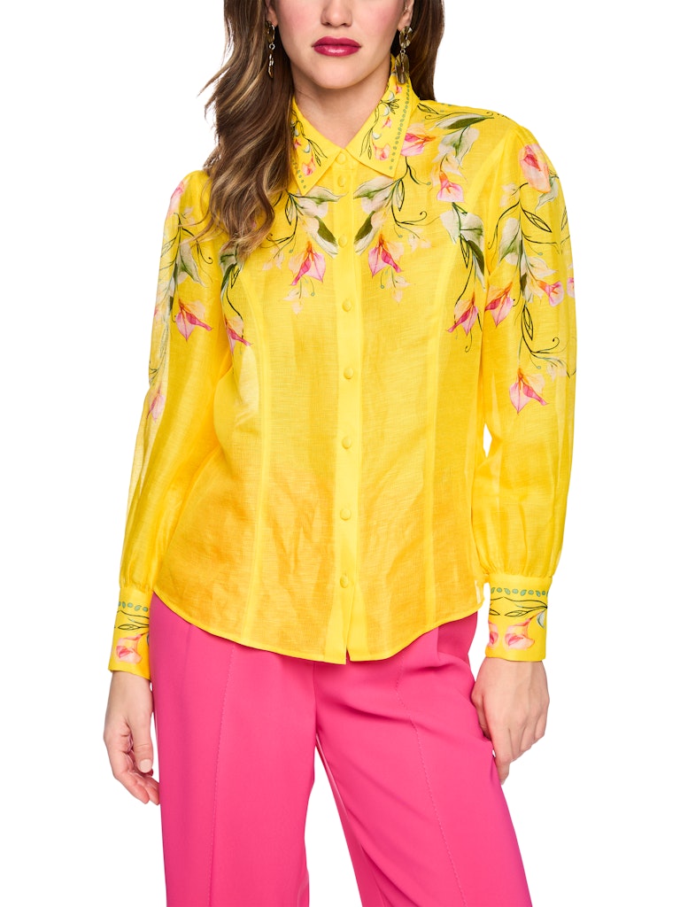 חולצה מכופתרת קלילה ואלגנטית, עשויה תערובת פשתן ומשי איכותית ונעימה. גזרה נשית ונינוחה, עם צווארון קלאסי, שרוולים ארוכים בסיומת חפתים רחבים מכופתרים, וסגירה באמצעות שורת כפתורים קדמית. הדפס צבעוני של דוגמת פרחי קאלה המעטר את החלק העליון של החולצה, הצווארון, והחפתים, מדגיש את העיצוב הייחודי.הרכב: 55% פשתן, 45% משיהדוגמנית בגובה 1.79 ולובשת מידה 3 של מארק קיין