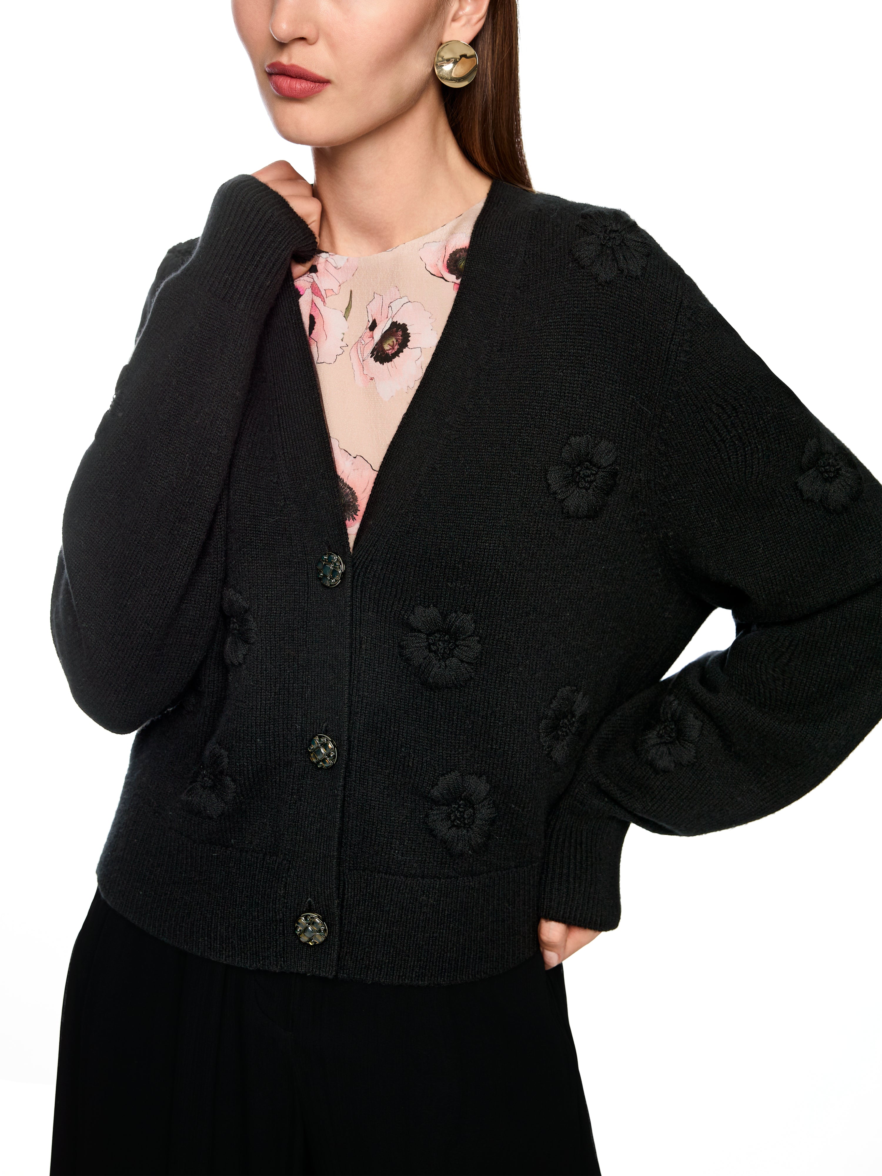 קרדיגן אלגנטי בצבע שחור, בגזרה רפויה עם מחשוף V ודוגמת פרחים רקומיםבעיטור כפתורי זהב עם קריסטליםהרכב בד: 90% צמר בתולי, 10% קשמירהדוגמנית בגובה 1.79 מ' ולובשת מידה 3 של מארק קיין