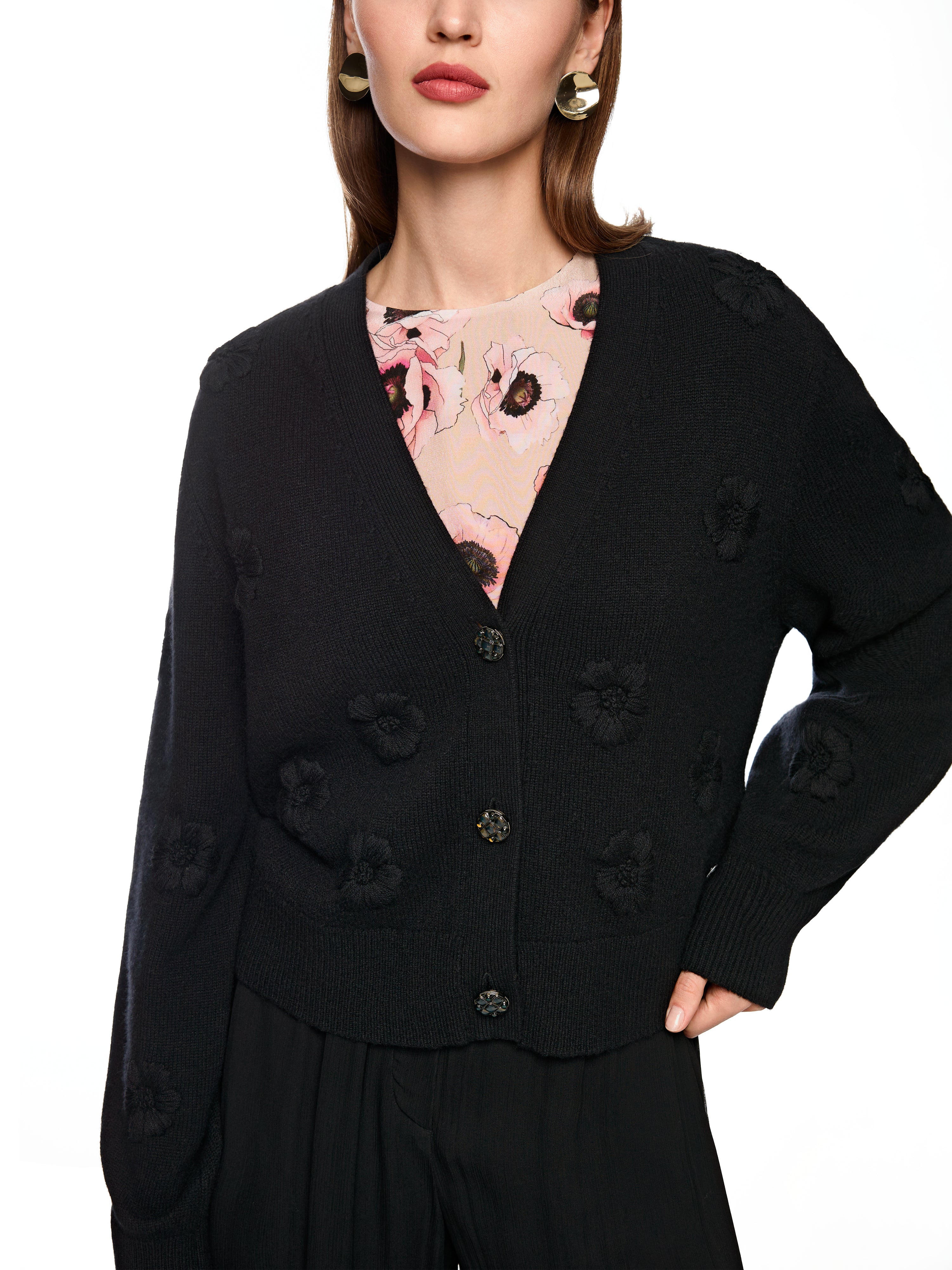 קרדיגן אלגנטי בצבע שחור, בגזרה רפויה עם מחשוף V ודוגמת פרחים רקומיםבעיטור כפתורי זהב עם קריסטליםהרכב בד: 90% צמר בתולי, 10% קשמירהדוגמנית בגובה 1.79 מ' ולובשת מידה 3 של מארק קיין