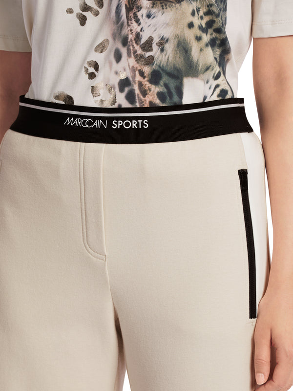 מכנסי כותנה במראה ספורטיבי גוון אוף וייט עם גומי במותן רגל רחבה עם פס לבן בצדדים