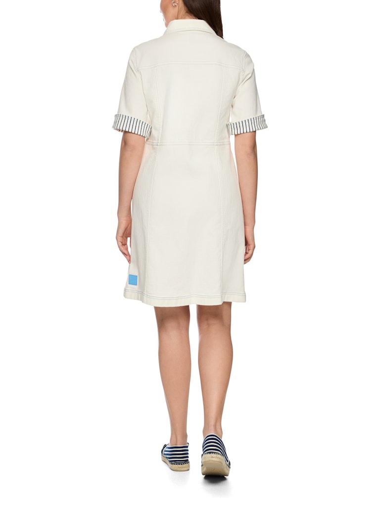 שמלת ג'ינס קצרה, בגזרה צמודה לגוף וצללית A, מבד דנים רך ואלסטי, עם עיטור רקמה בדוגמת מוטיבים מעולם הספינות. לשמלה שרוולים קצרים עם מכפלת רחבה ומתקפלת בדוגמת פסים, צווארון קלאסי, וסגירה באמצעות כפתורים כסופים לכל האורך.הרכב: 98% כותנה, 2% אלסטןהדוגמנית בגובה 1.79 ולובשת מידה 3 של מארק קיין