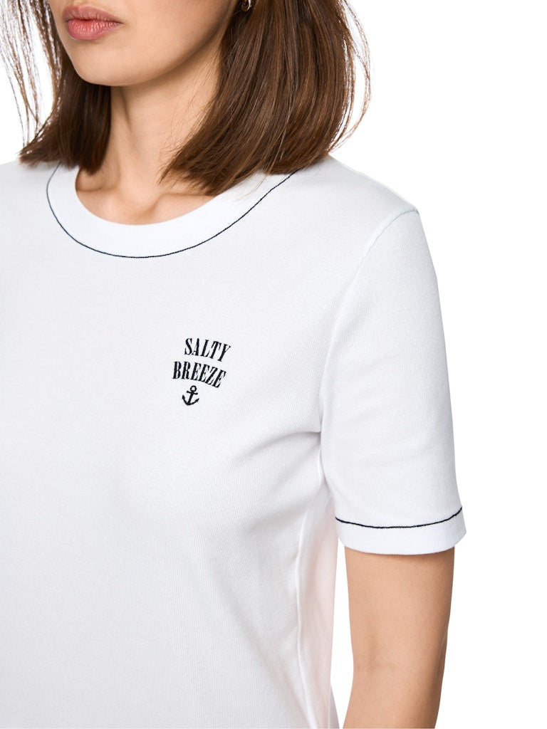 טישירט בגזרה צמודה לגוף, מבד כותנה רך וגמיש בטקסטורת פסי ריב. עם שרוולים קצרים, צווארון עגול, ועיטור רקמה קטן בדש החולצה.הרכב: 94% כותנה, 6% אלסטןהדוגמנית בגובה 1.79 ולובשת מידה 3 של מארק קיין