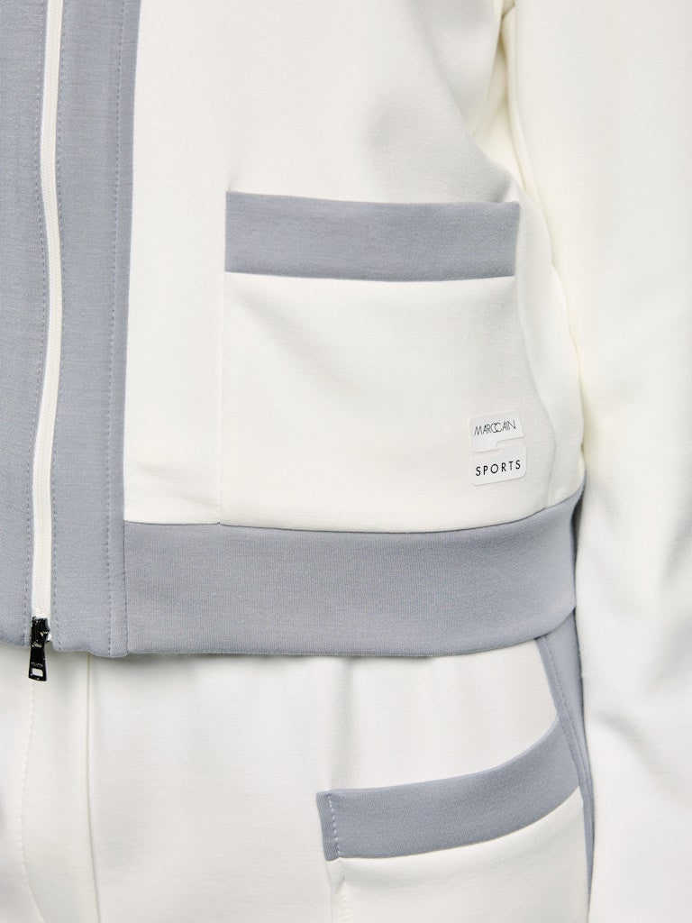 ז'קט בעיצוב ספורטיבי וקלאסי, בגזרה ישרה, עשוי בד רך ונעים במיוחד, בשילוב דיטיילס של פסים בגוון אפור. עם שרוולים ארוכים בסיומת מנג'ט, צווארון עומד, שני כיסים חזיתיים, וסגירה באמצעות רוכסן דו כיווני.הרכב: 47% פוליאמיד, 44% ויסקוזה, 9% אלסטןהדוגמנית בגובה 1.79 ולובשת מידה 3 של מארק קיין