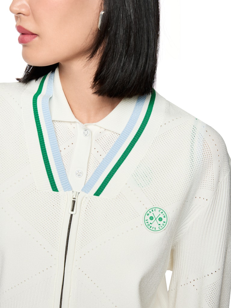 קרדיגן בעיצוב ספורטיבי, עשוי סריג ויסקוזה רך וקליל, עם דוגמת חורים עדינה. גזרה ישרה ונינוחה, עם רוכסן דו כיווני לסגירה, צווארון וי, ושרוולים ארוכים בגימור פסים צבעוניים.הרכב: 78% ויסקוזה, 22% פוליאסטרהדוגמנית בגובה 1.79 ולובשת מידה 3 של מארק קיין