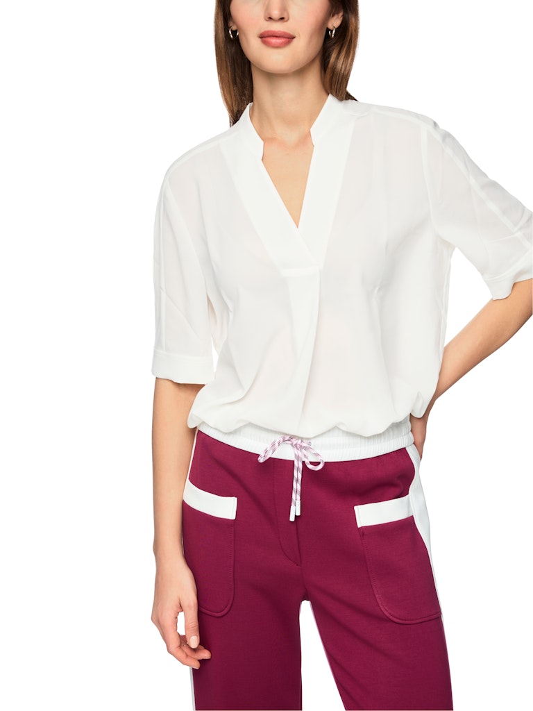 חולצה בגזרה רחבה, מבד קליל וזורם. עם שרוולים קצרים, וצווארון V עם קפל בתחתית המקנה לה צללית ייחודית. הרכב: 100% פוליאסטרהדוגמנית בגובה 1.79 ולובשת מידה 3 של מארק קיין