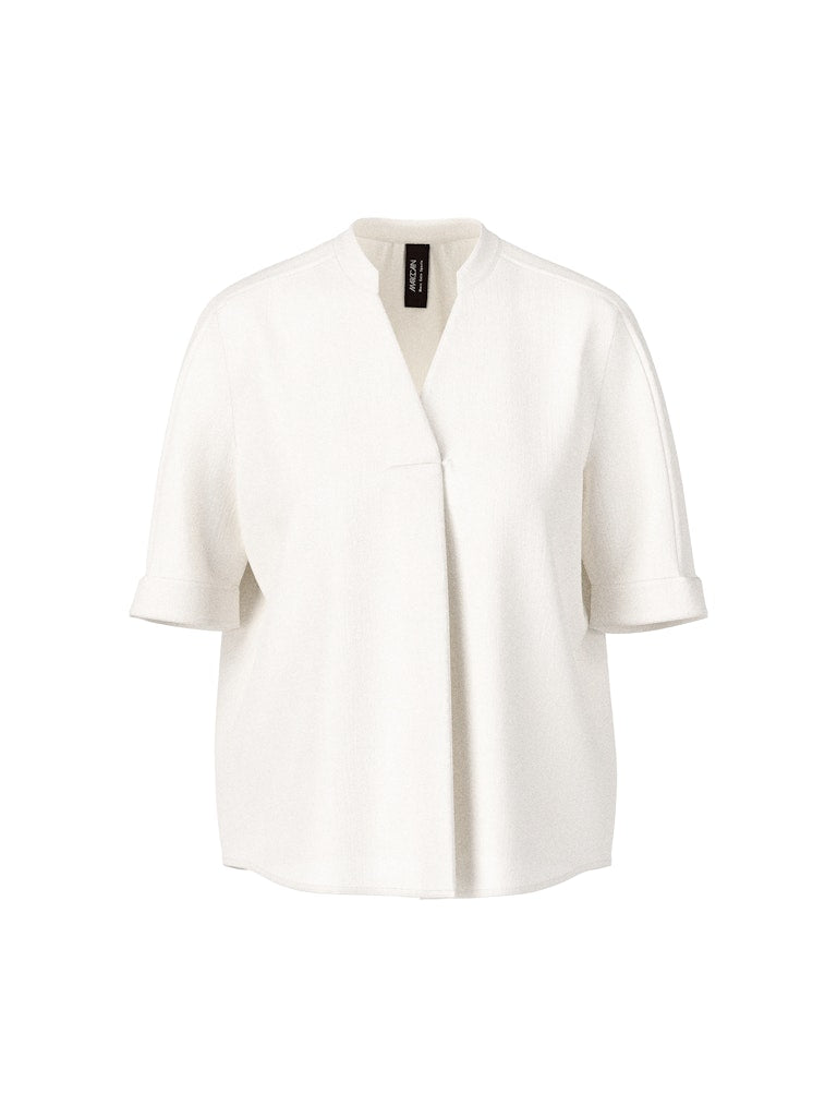 חולצה בגזרה רחבה, מבד קליל וזורם. עם שרוולים קצרים, וצווארון V עם קפל בתחתית המקנה לה צללית ייחודית. הרכב: 100% פוליאסטרהדוגמנית בגובה 1.79 ולובשת מידה 3 של מארק קיין