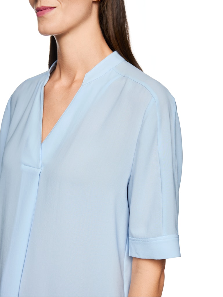 חולצה בגזרה רחבה, מבד קליל וזורם. עם שרוולים קצרים, וצווארון V עם קפל בתחתית המקנה לה צללית ייחודית. הרכב: 100% פוליאסטרהדוגמנית בגובה 1.79 ולובשת מידה 3 של מארק קיין