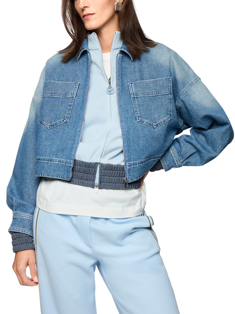 ז'קט ג'ינס באורך קצר ובגזרה נינוחה, בגוון כחול עם שטיפה ייחודית המעניקה לו מראה וינטג' אופנתי. עם צווארון קלאסי, שרוולים ארוכים בסיומת חפתים מכופתרים, כיסי פאץ' חזיתיים, וסגירה באמצעות רוכסן.הרכב: 99% כותנה, 1% אלסטןהדוגמנית בגובה 1.79 ולובשת מידה 3 של מארק קיין