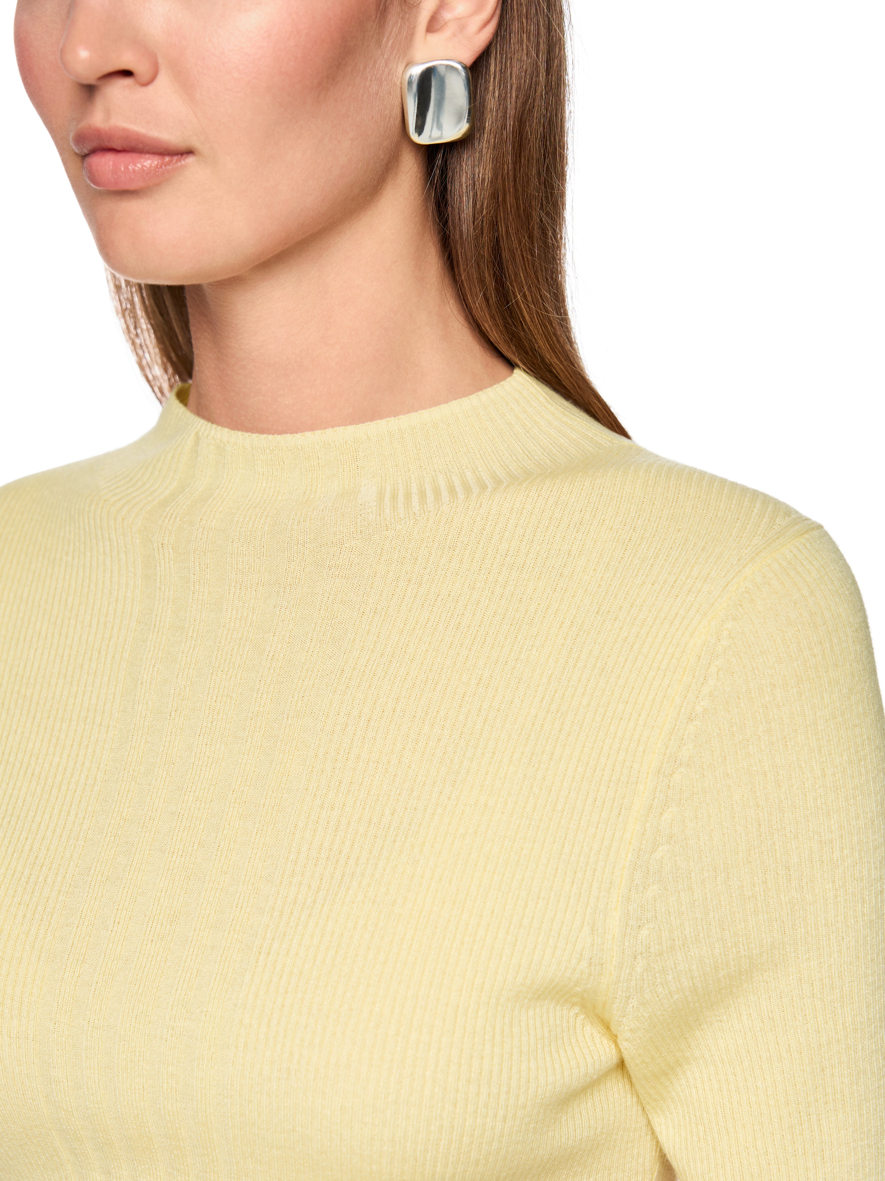 סריג בגזרה צמודה עם צווארון עגול ושרוולים קצריםהרכב: 47% צמר, 38% ויסקוזה, 10% פוליאמיד, 5% קשמירהדוגמנית בגובה 1.79 ולובשת מידה 3 של מארק קיין 