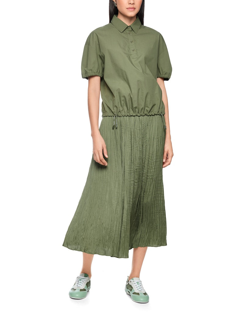 חולצה קצרה בגזרה רחבה ונינוחה, עשויה כותנה אורגנית טהורה, רכה ונעימה במיוחד. לחולצה צווארון קלאסי עם סגירת כפתורים, שרוולים קצרים ותפוחים עם סיומת כיווצים אלסטית, ומכפלת עם שרוכי קשירה בסגנון ספורטיבי, המאפשרים התאמת רוחב אישית.הרכב: 100% כותנה אורגניתהדוגמנית בגובה 1.79 ולובשת מידה 3 של מארק קיין