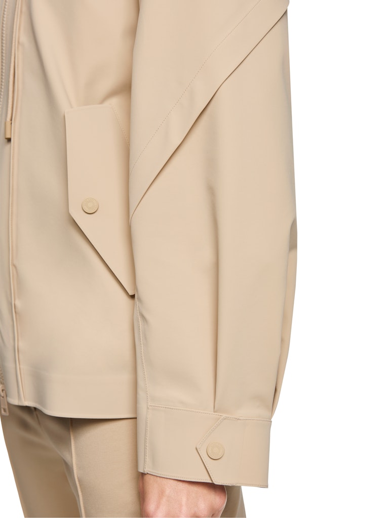 ז'קט בסגנון מעיל מטיילים ספורטיבי, עשוי חומר עמיד, גמיש וקל משקל. עם כובע קפוצ'ון, זוג כיסי צד בסגירת תיקתקים, שרוולים ארוכים בסיומת חפתים, ורוכסן קדמי דו כיווני. חיתוכים גיאומטריים ותוספות דיטיילס משלימים את המראה האופנתי. ללוק מלא בסטייל ושימושי בכל מזג אוויר.הרכב: 86% פוליאמיד, 14% אלסטןהדוגמנית בגובה 1.79 ולובשת מידה 3 של מארק קיין